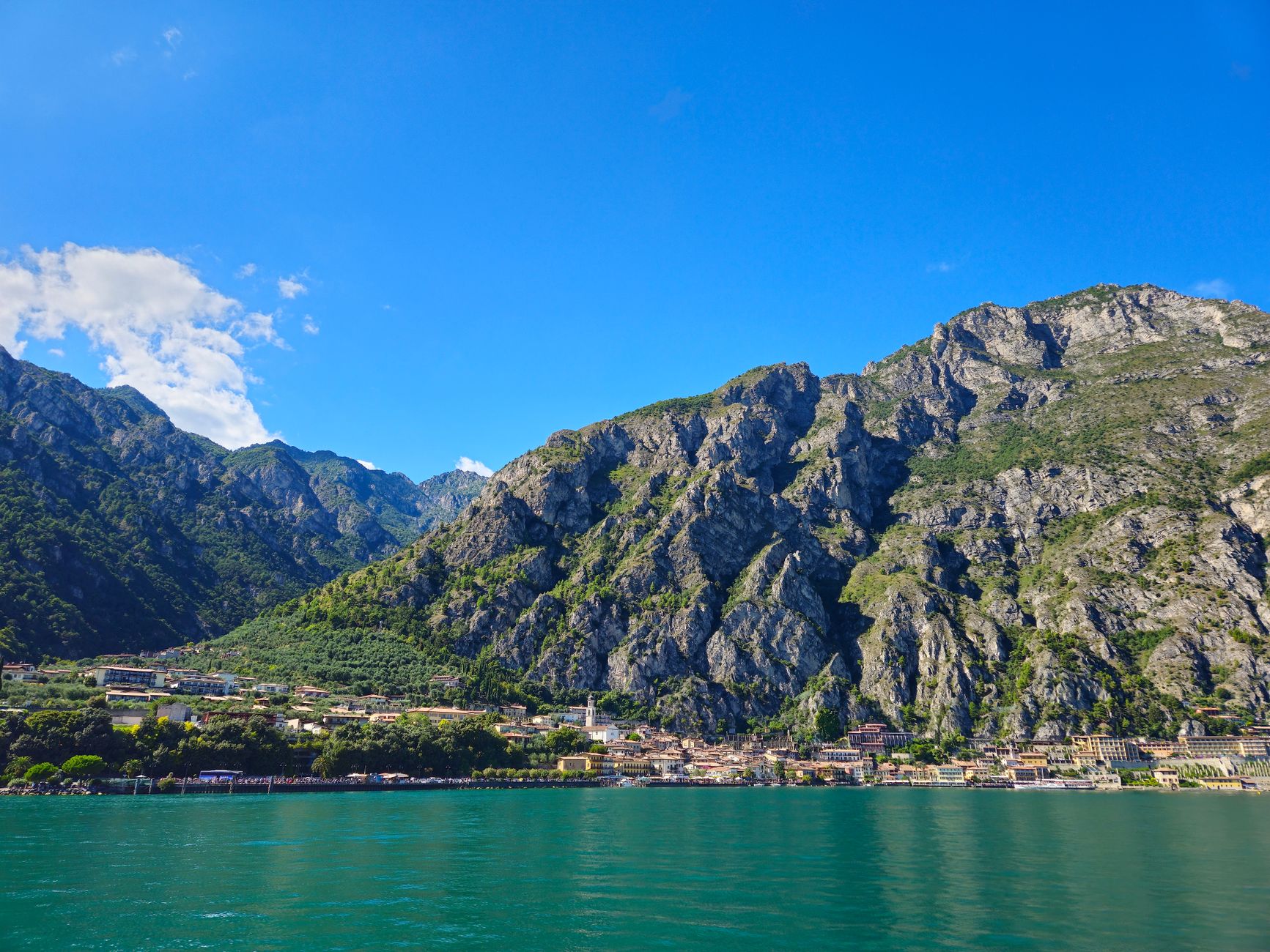 Barevné domy a přístav městečka Limone sul Garda sevřeného mezi skály a hladinu jezera