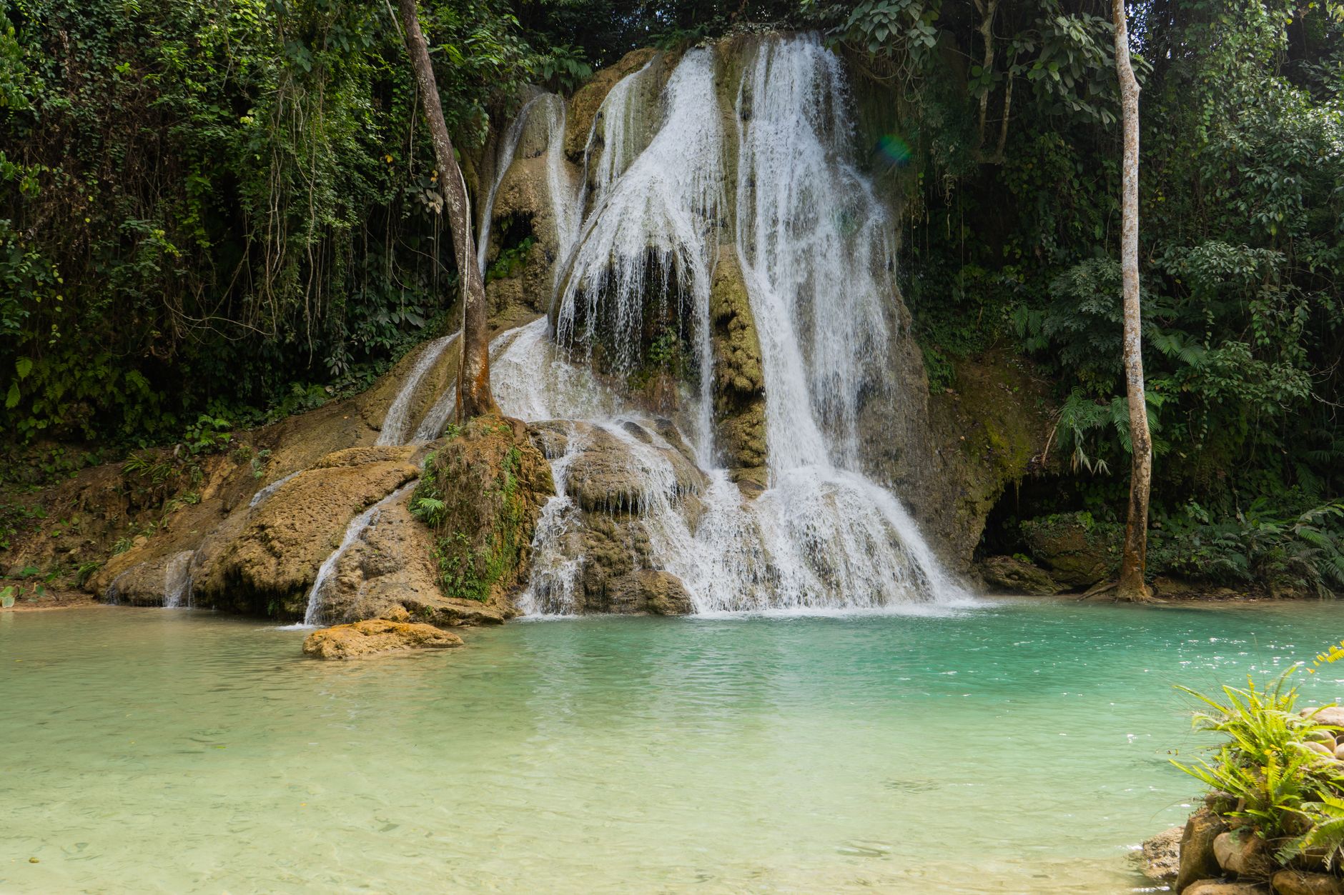 Tyrkysové kaskádové tůně vodopádů Kuang Si obklopené tropickou džunglí v Laosu