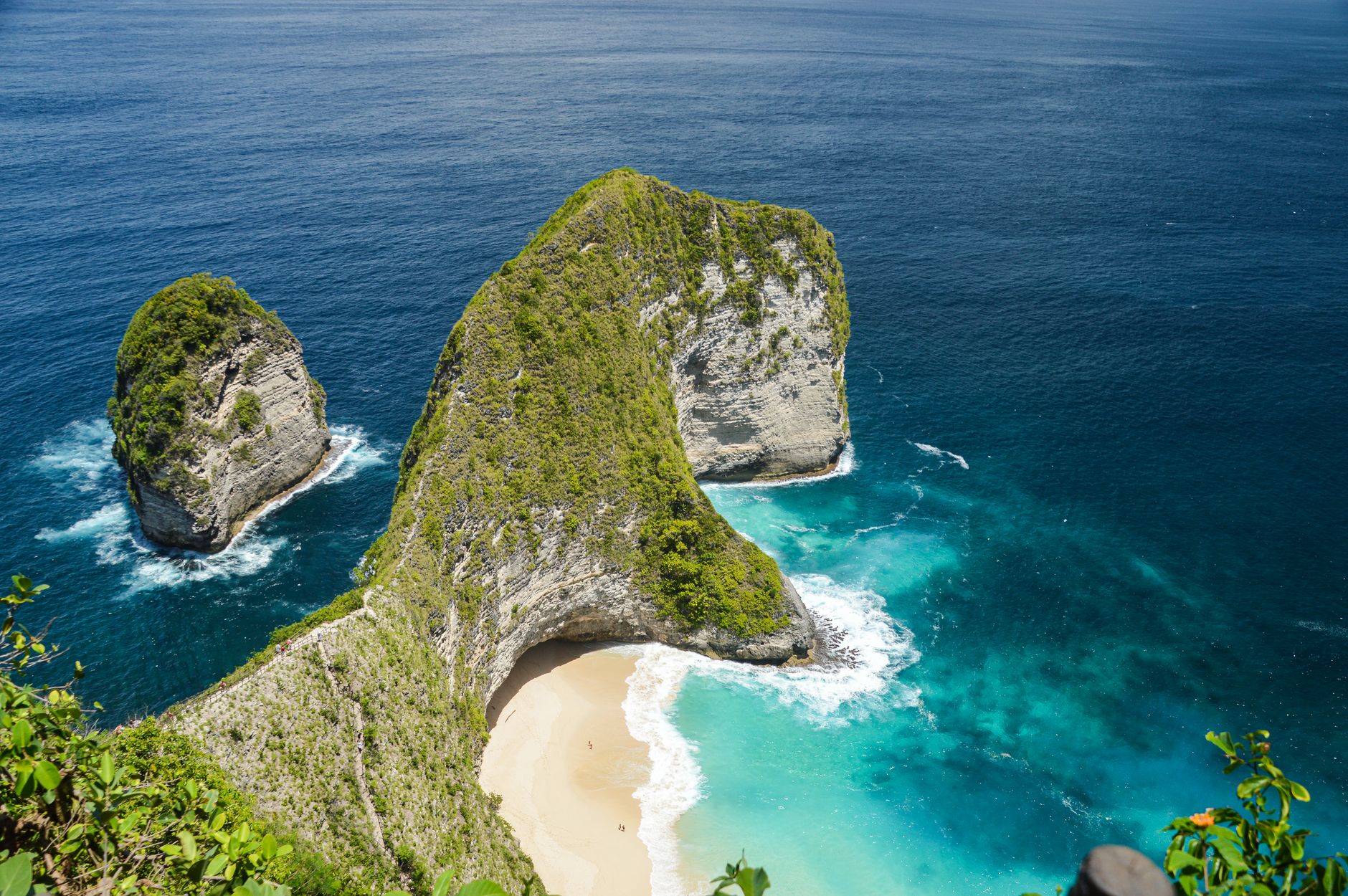 Útes Kelingking Beach na Nusa Penida ve tvaru hřbetu dinosaura nad bílou pláží a tyrkysovým mořem