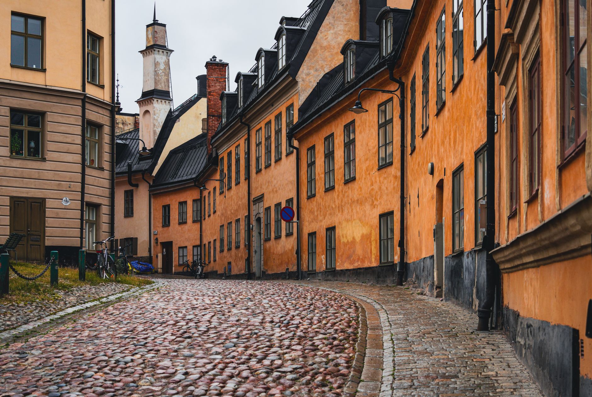 Historické dřevěné domy a dlážděná ulice ve skanzenu Gamla Linköping ve Švédsku