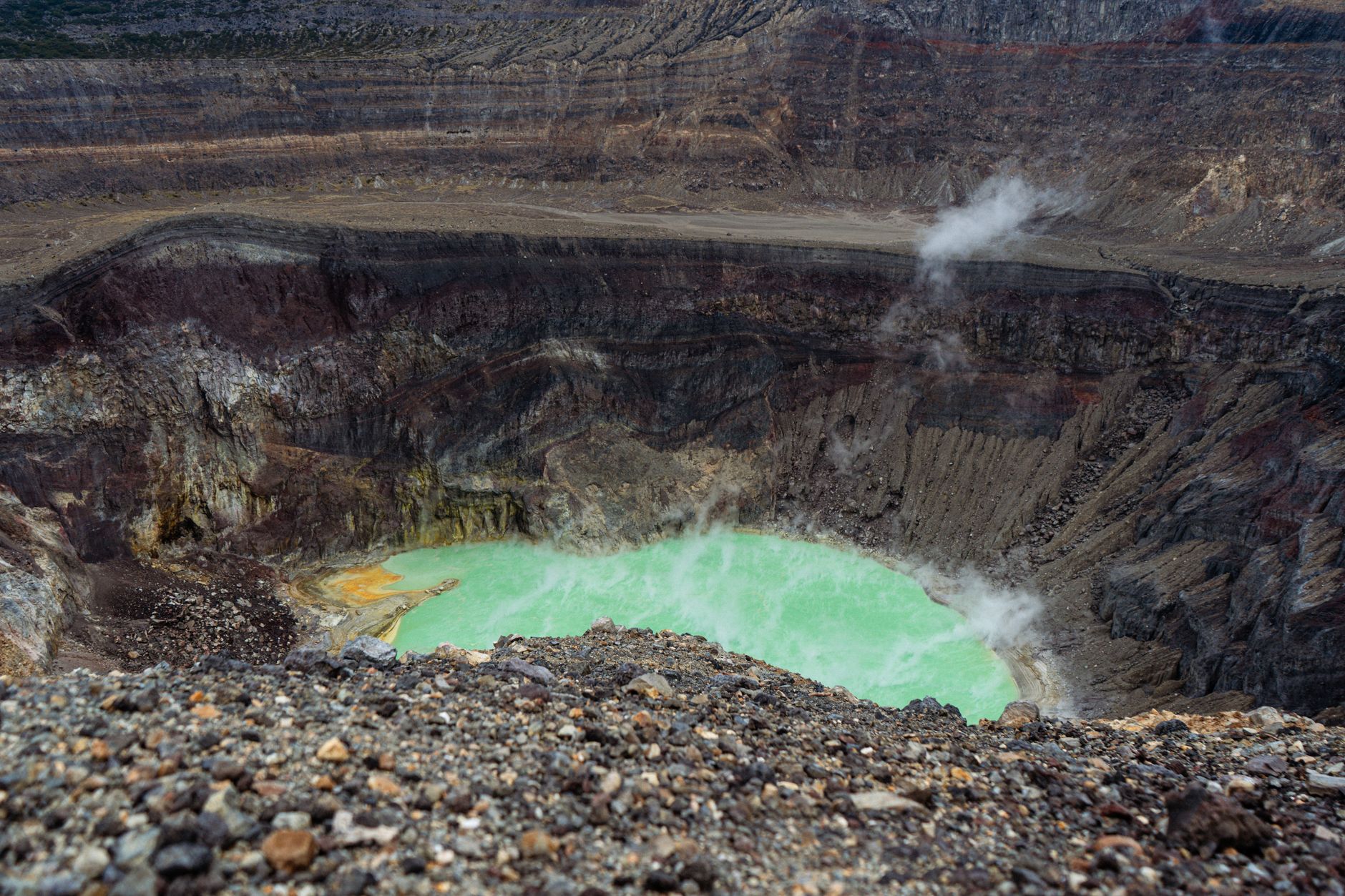 Okraj kráteru Gran Cratere na ostrově Vulcano s žlutými sirnými usazeninami a výhledem na moře