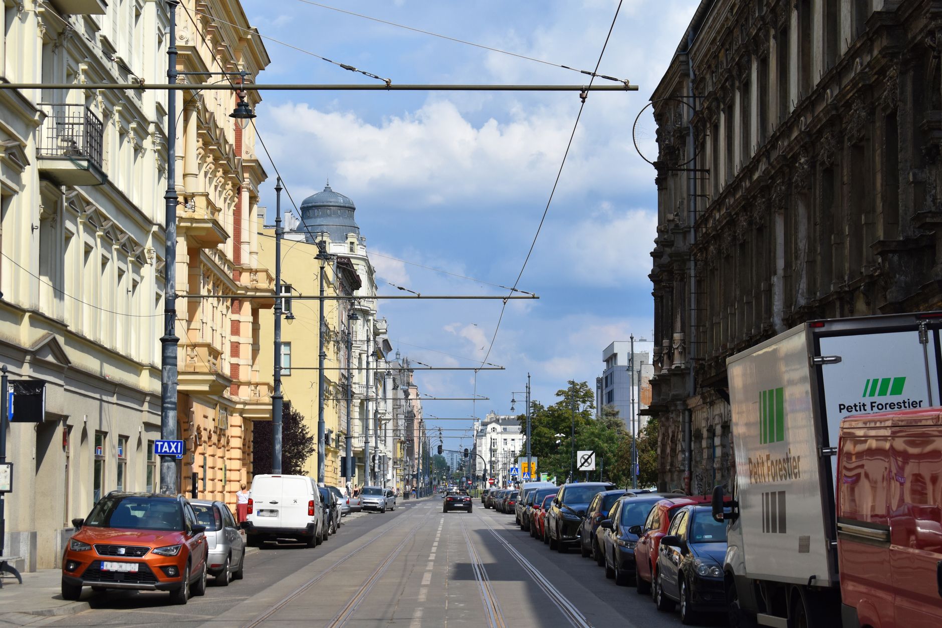 Pohled na třídu Piotrkowska v Lodži s historickými secesními fasádami a litinovými lampami