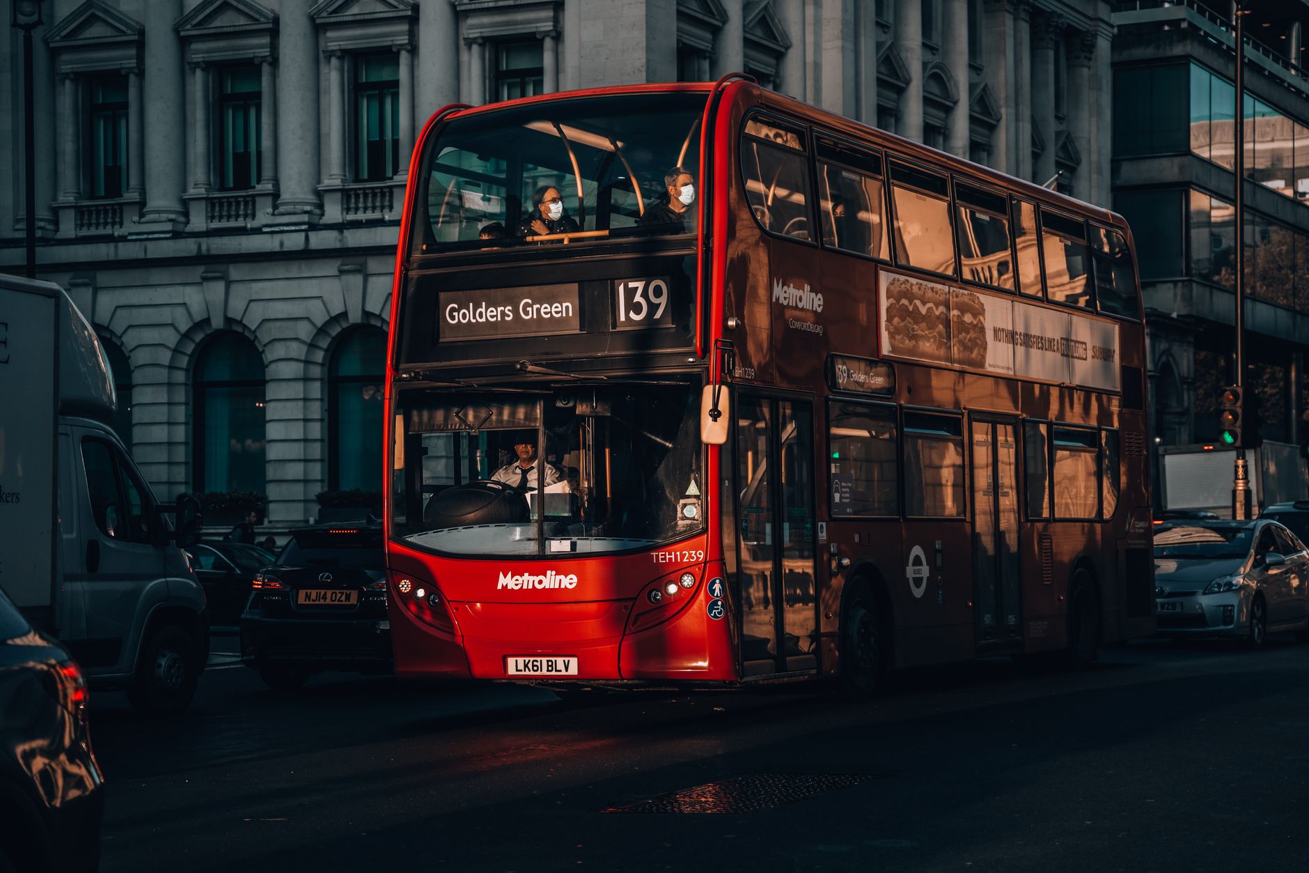 Červený patrový autobus double-decker projíždí ulicí v centru Londýna
