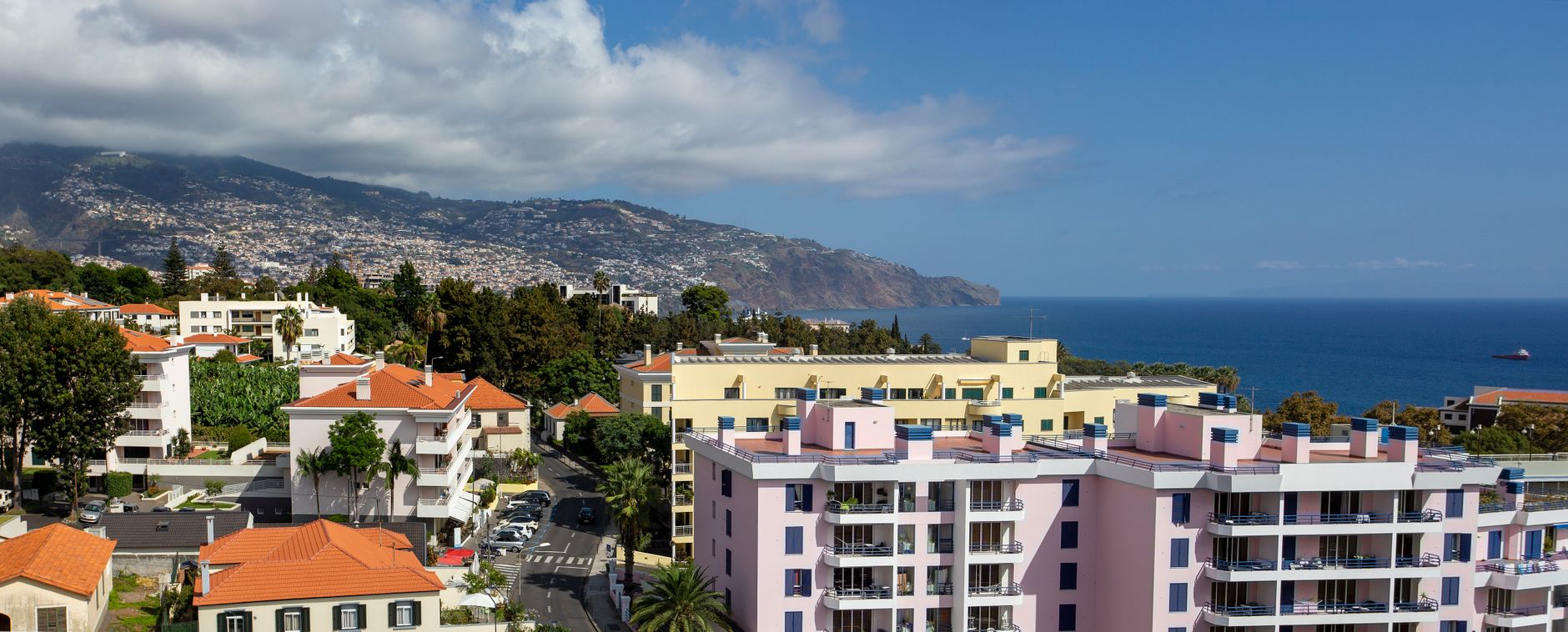 Barevné domky a přístav historického města Funchal na Madeiře pod horami