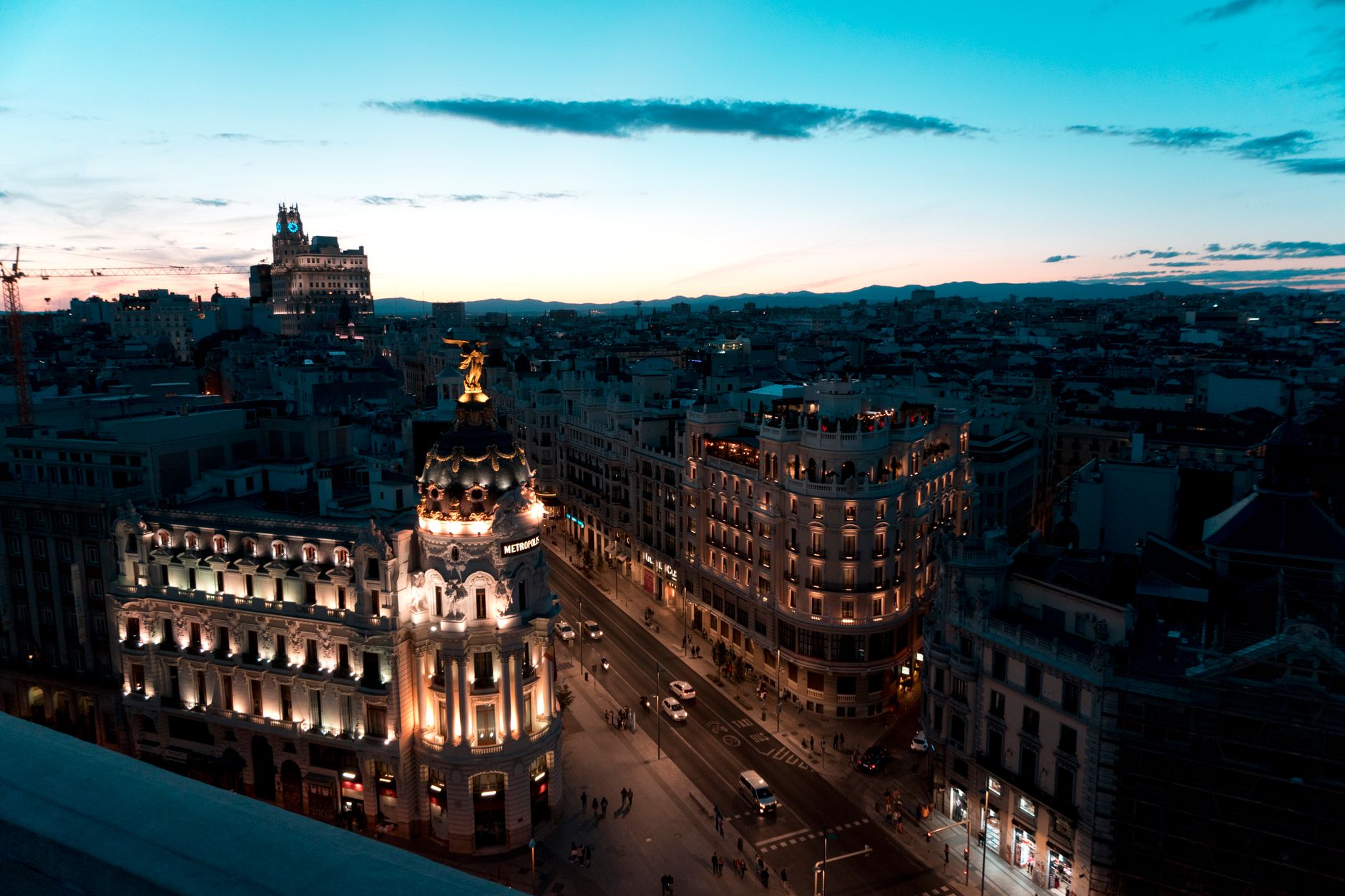Bulvár Gran Vía v Madridu s historickými budovami a budovou Metropolis za soumraku