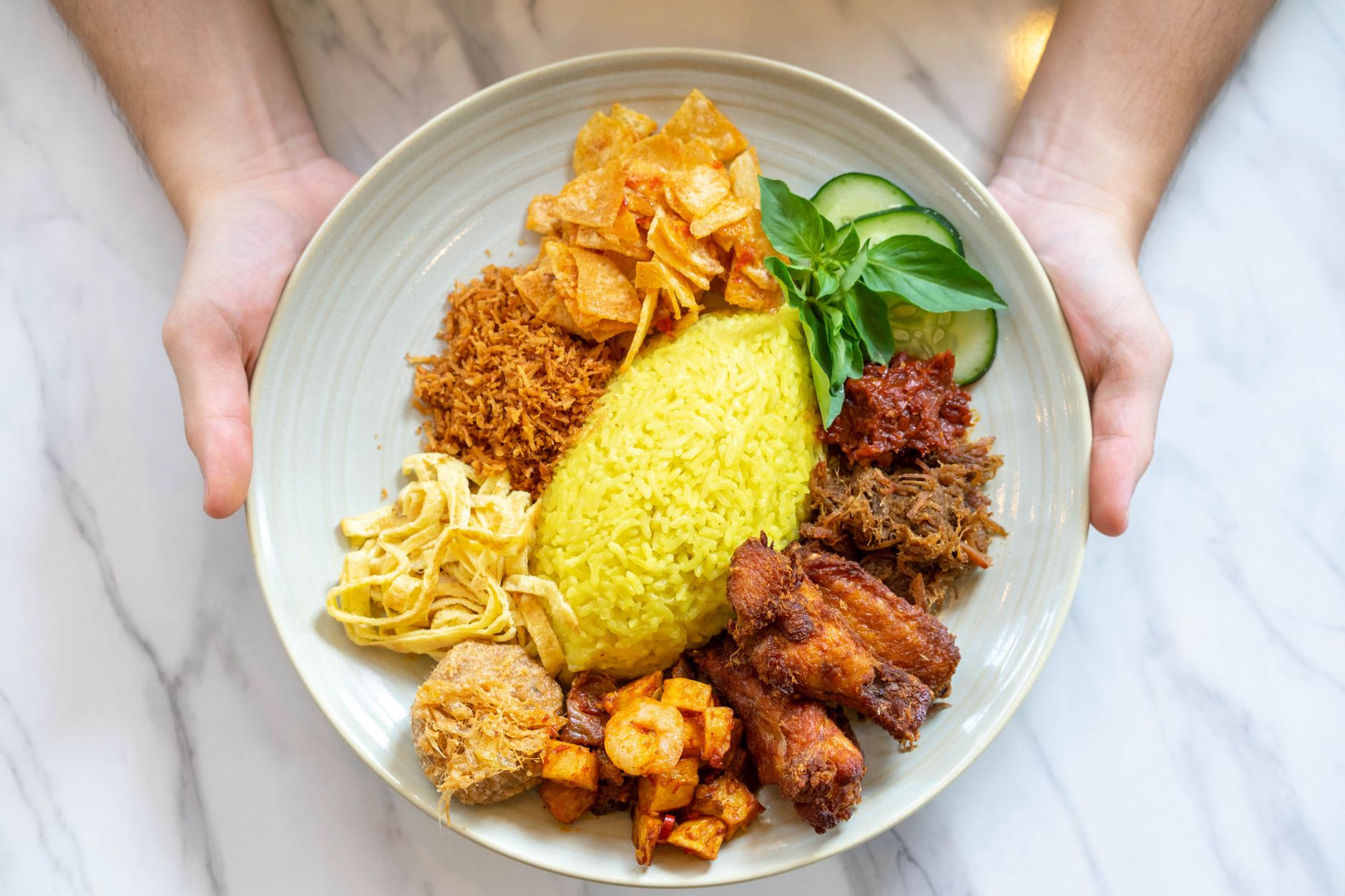 Talíř nasi lemak s rýží v kokosovém mléce, sambalem a oblohou