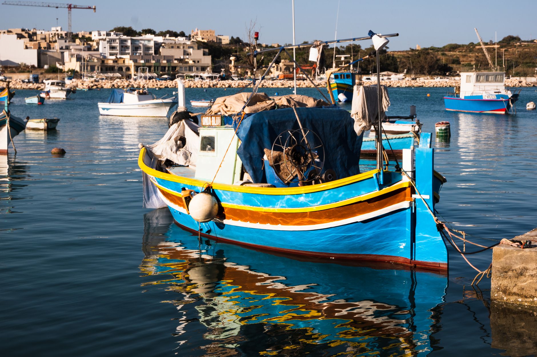 Barevné maltské rybářské loďky luzzu s namalovaným okem na přídi kotvící v přístavu Marsaxlokk