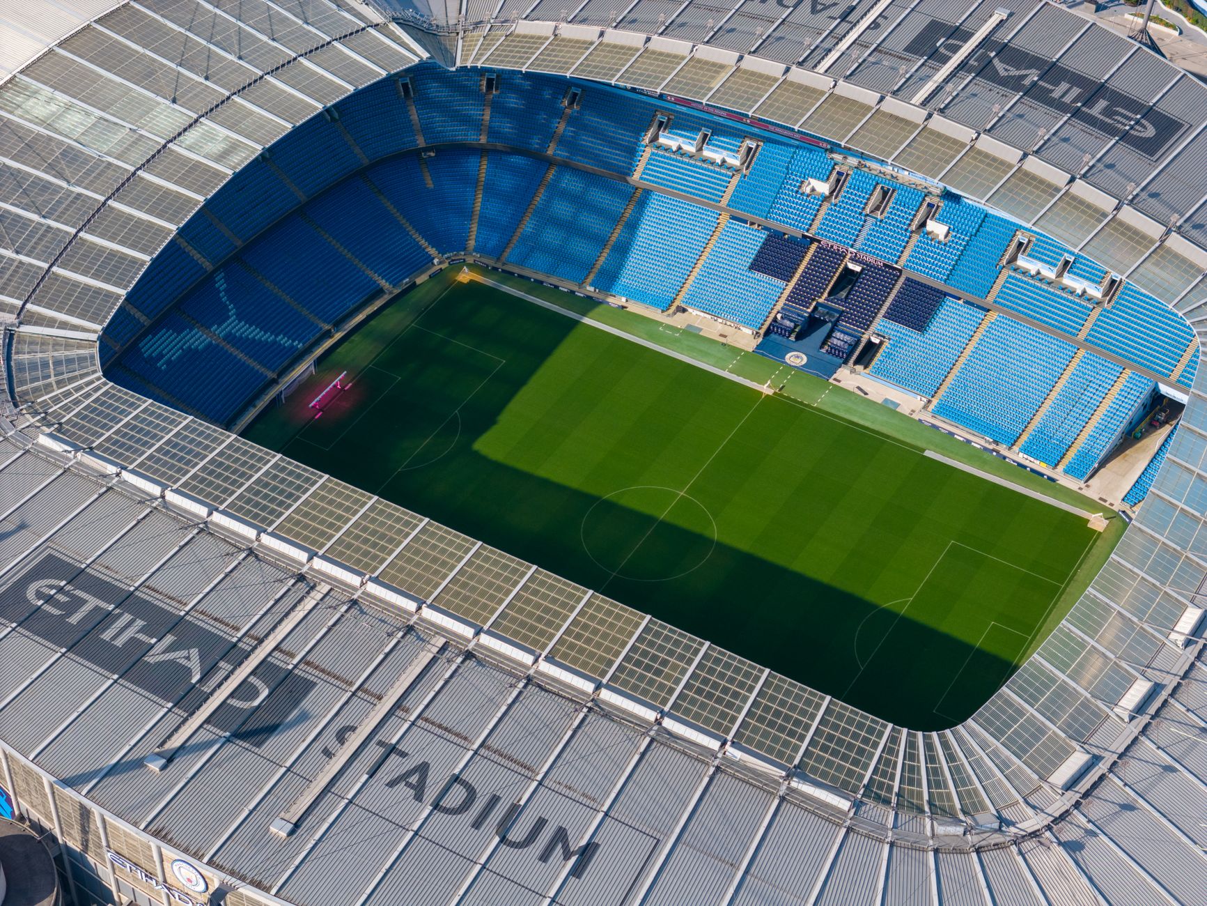 Velký fotbalový stadion v Manchesteru s prázdnými tribunami a travnatým hřištěm