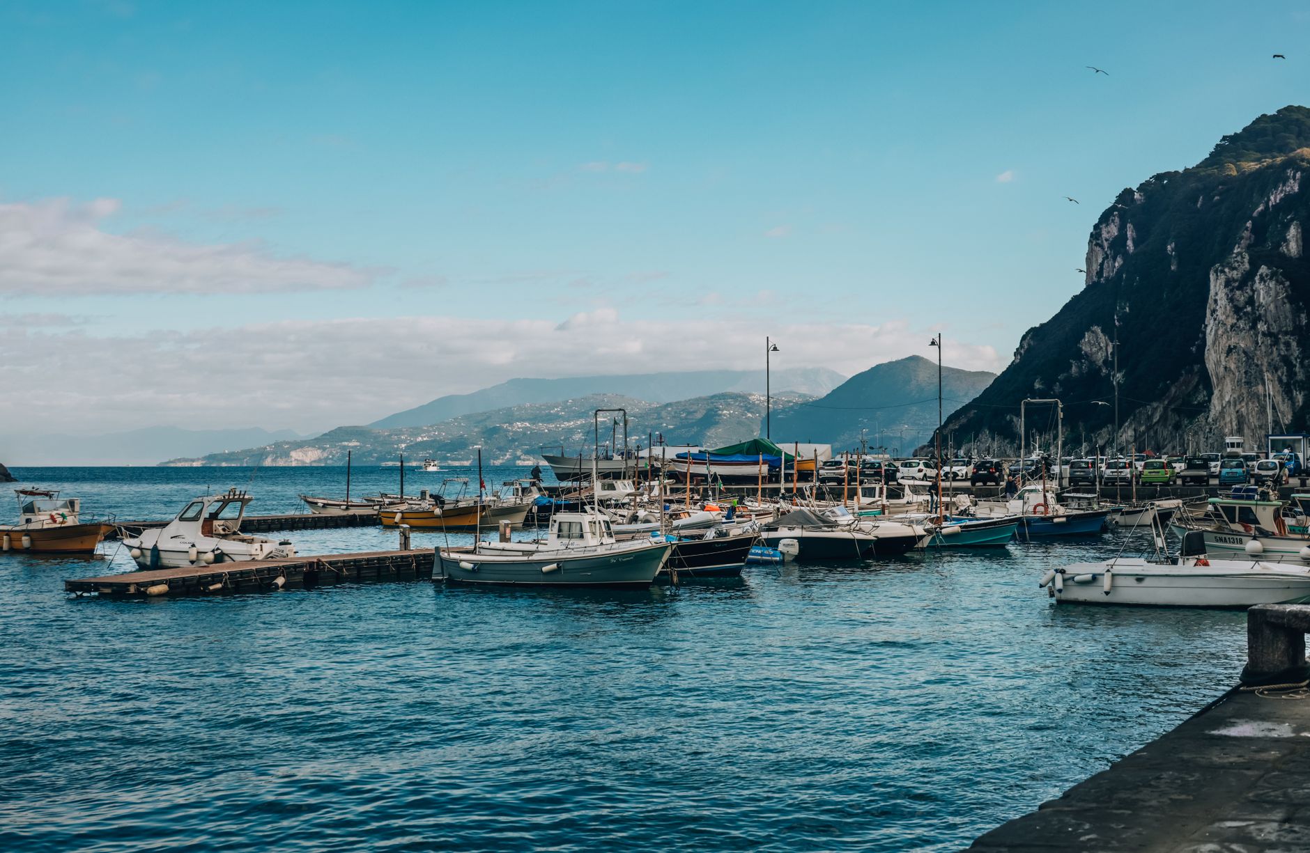 Marina di Maratea přístav s rybářskými loděmi a útesy nad tyrkysovým Tyrhénským mořem
