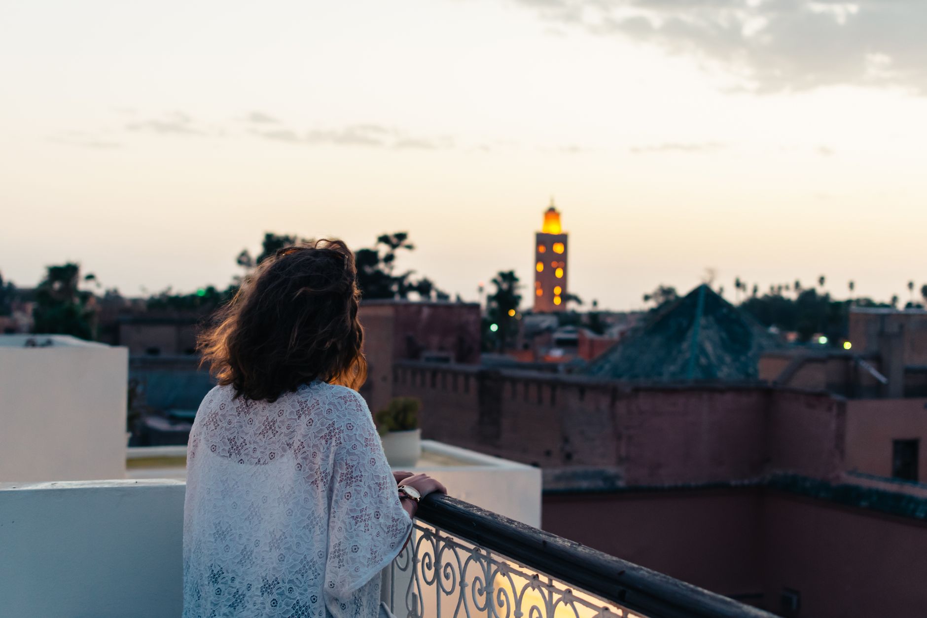 Panorama medíny v Marrákeši s minaretem Koutoubia a pohořím Atlas v pozadí za soumraku