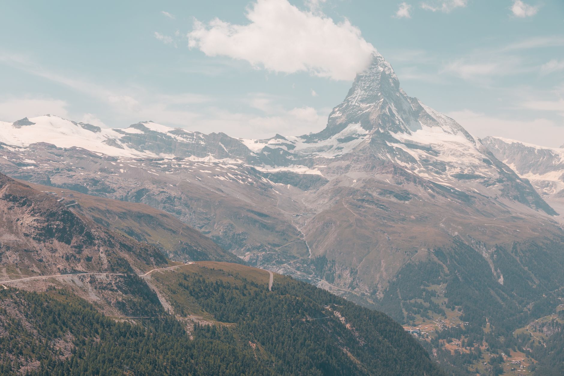 Hora Matterhorn s charakteristickým pyramidovým vrcholem nad alpskou krajinou ve Švýcarsku za jasného dne