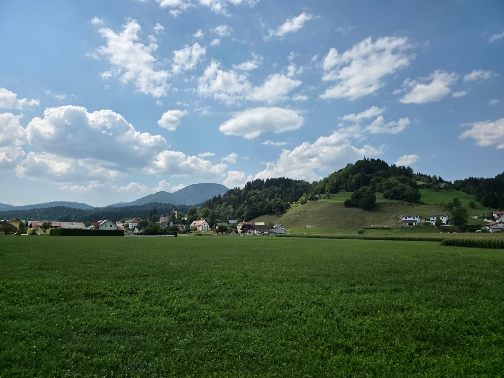Rovinatá krajina Prekmurje se zemědělskými poli a větrnou pumpou ve slovinsku