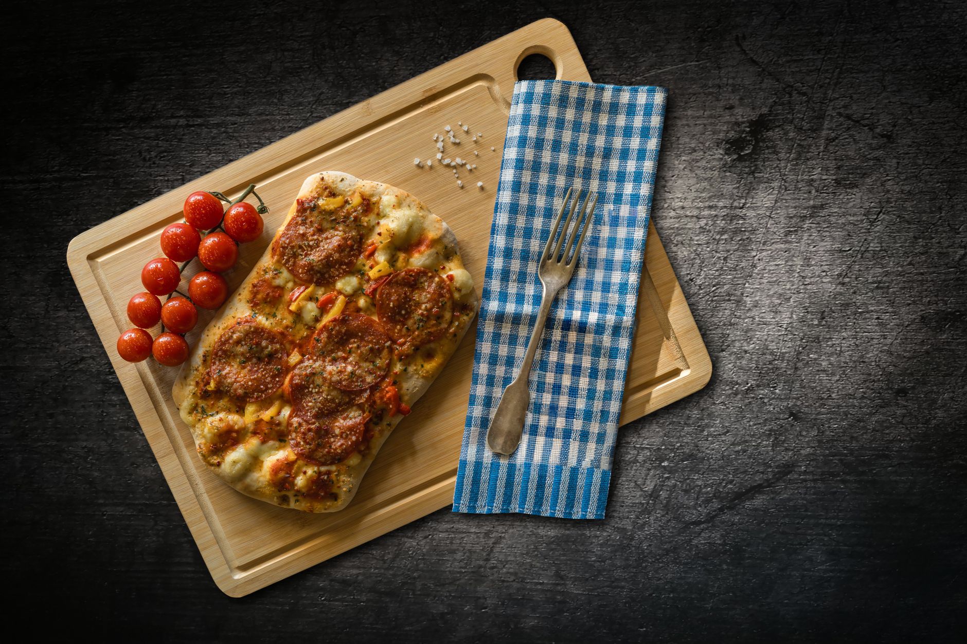 Tenká alsaská tarte flambée flammekueche se smetanou cibulí a slaninou na dřevěném prkénku