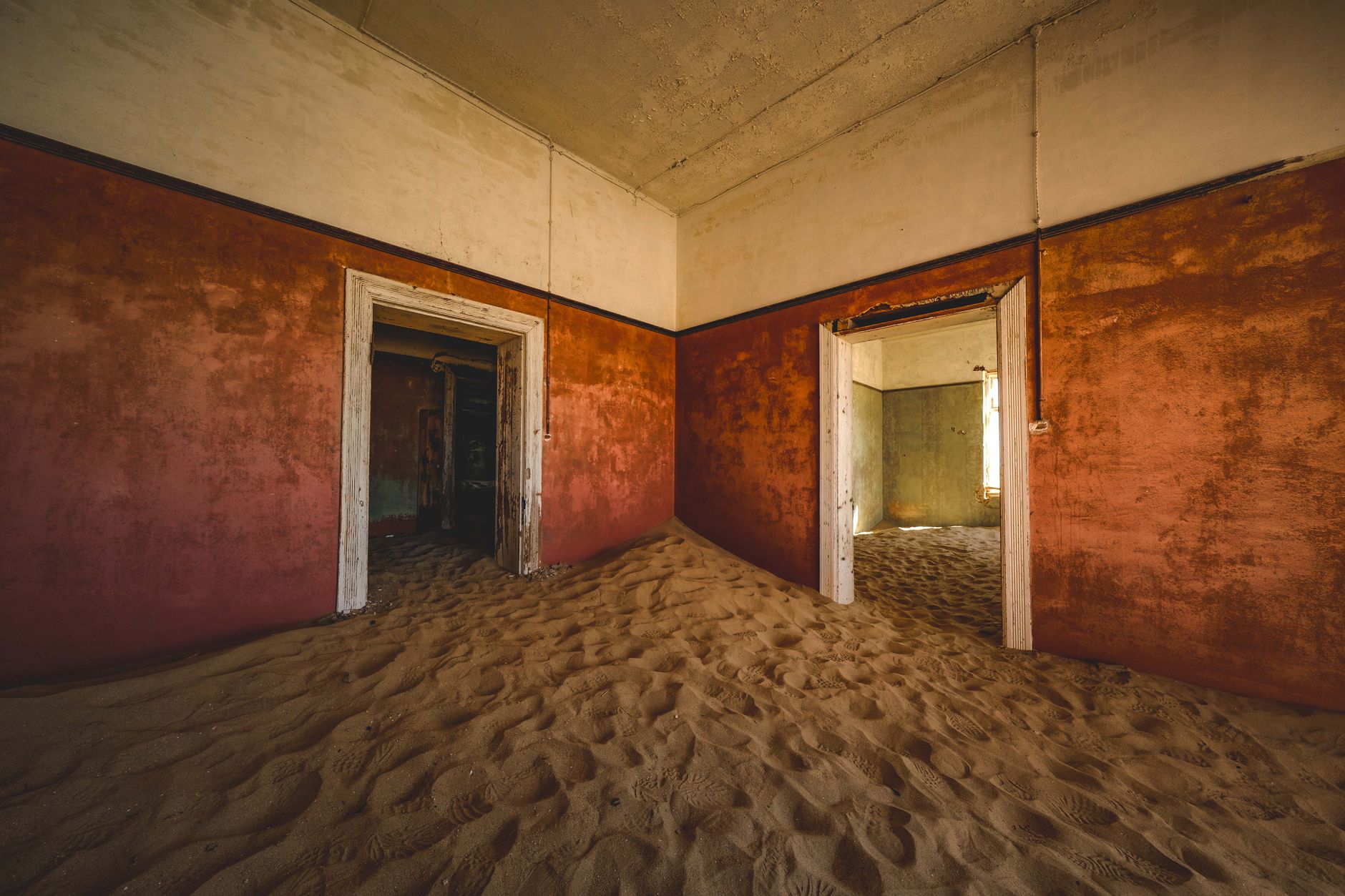 Opuštěný dům v Kolmanskopu zaplněný pouštním pískem, vraky koloniální architektury v Namibii