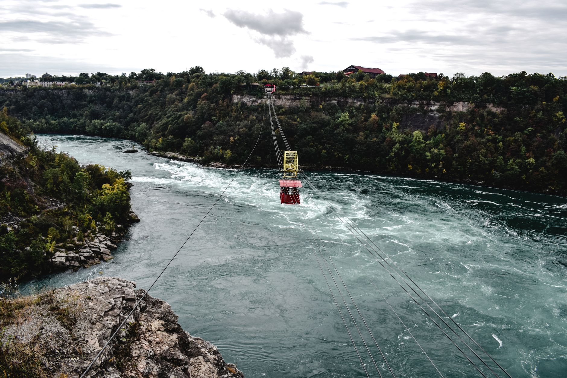 Barevně nasvícené Niagarské vodopády po setmění s odraznou mlhou v duhových barvách