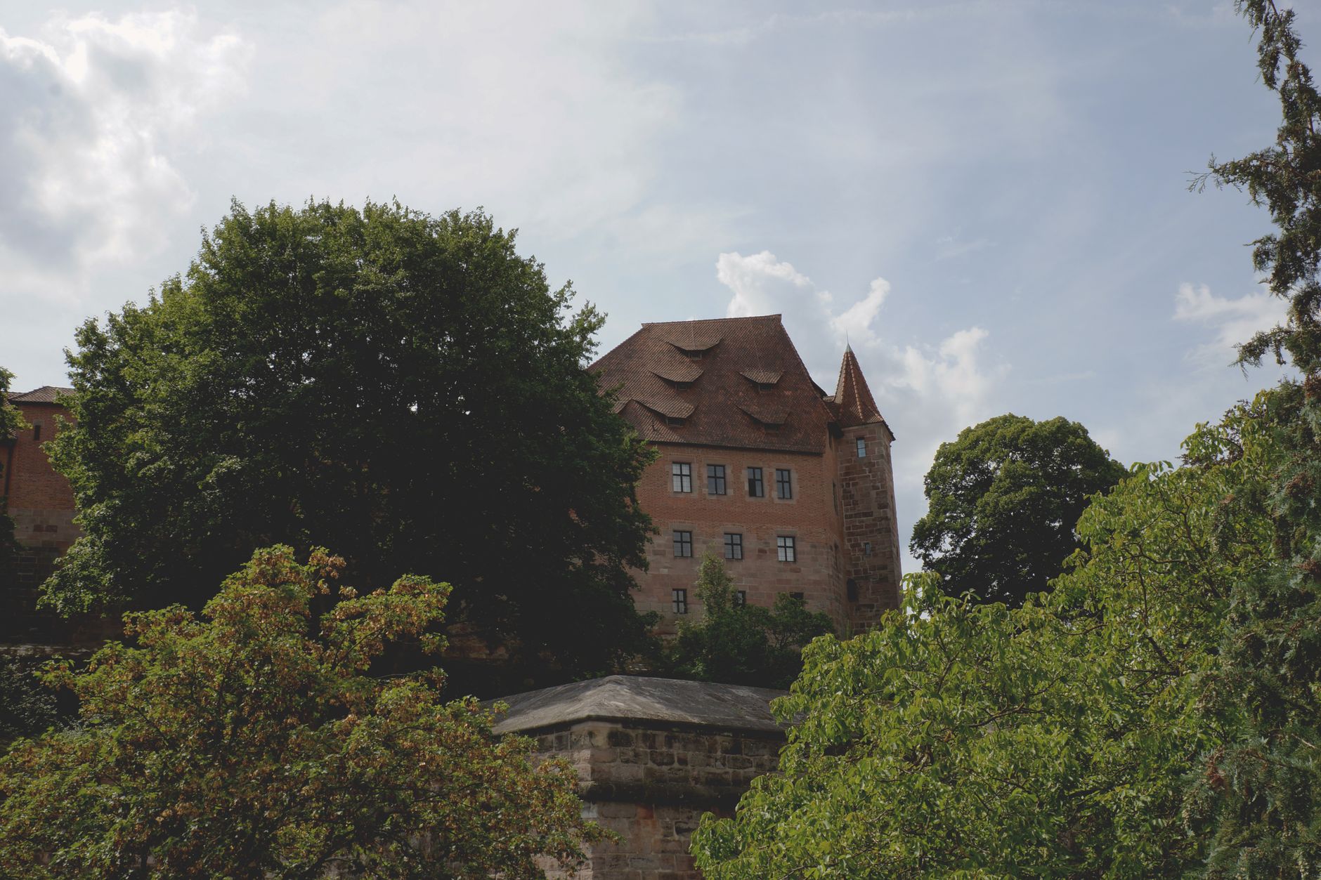 Středověký hrad Kaiserburg v Norimberku s kamennou věží a hrázděnými budovami