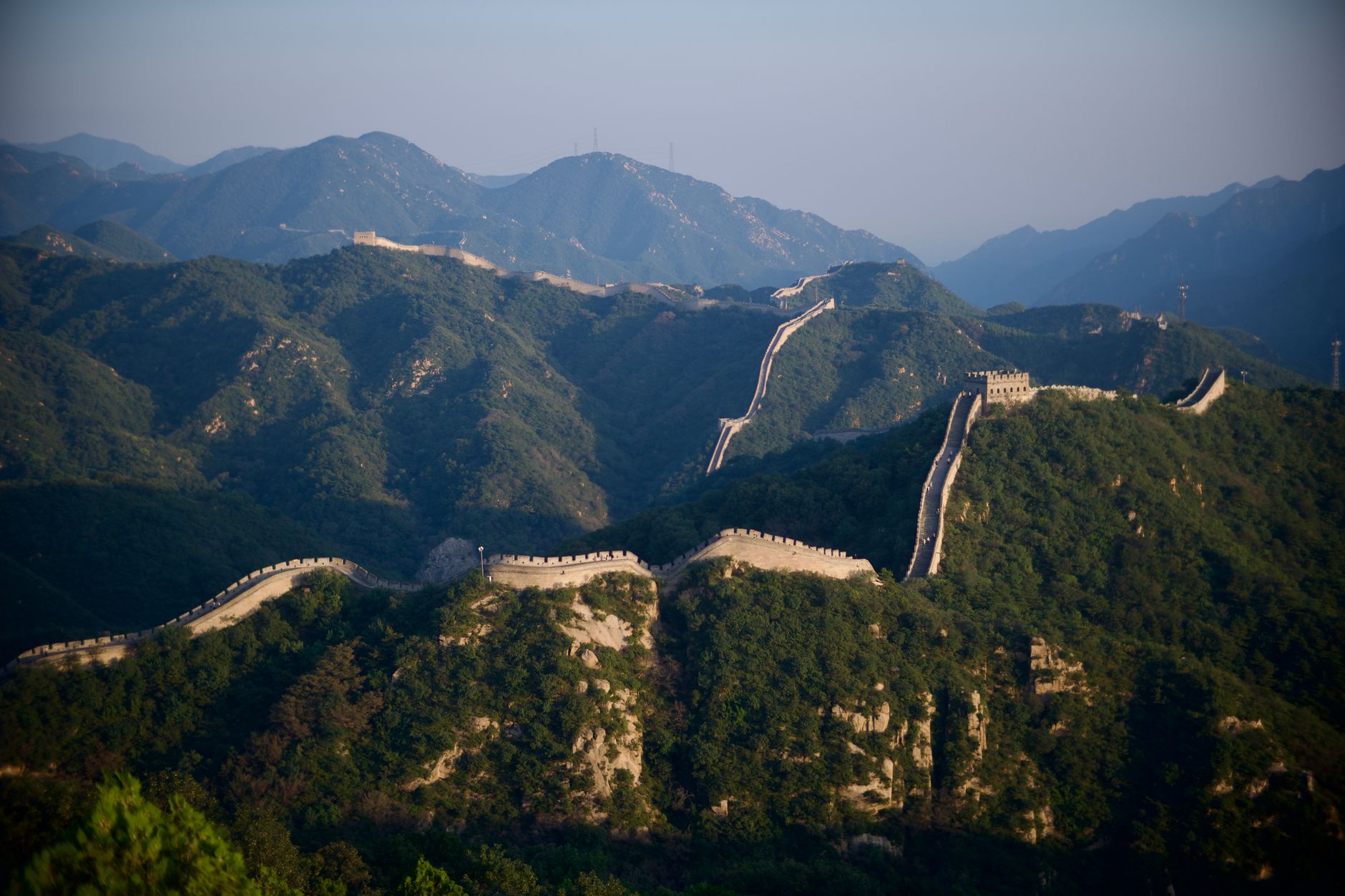 Úsek Velké čínské zdi vinoucí se po hřebenech zalesněných hor u Pekingu