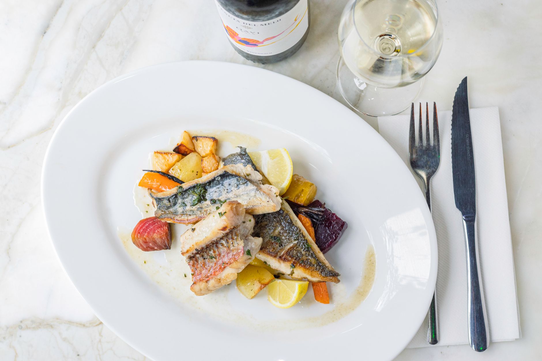 Talíř grilované čerstvé ryby s citronem a místními brambory v portugalské restauraci
