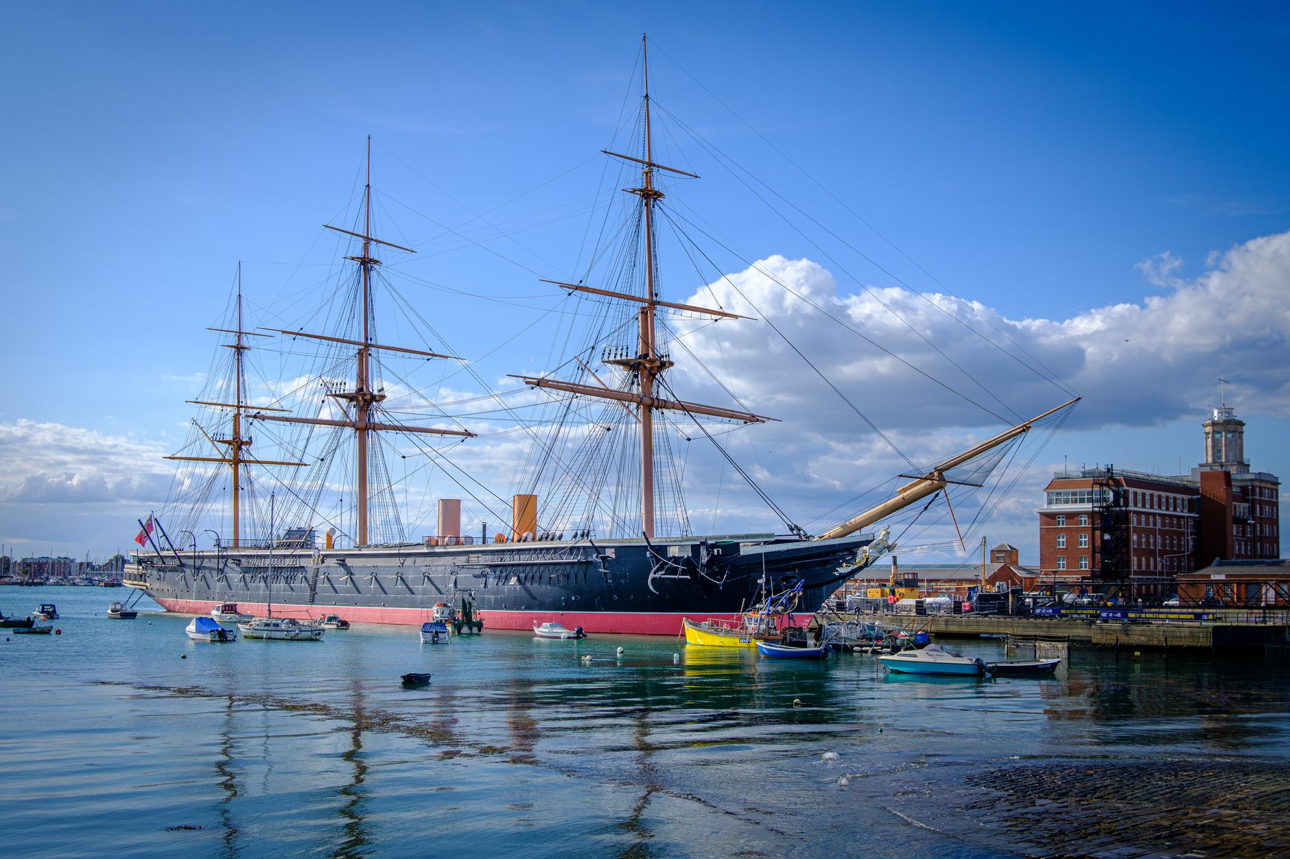 Panorama přístavu Portsmouth s věží Spinnaker Tower a kotvícími loděmi za soumraku