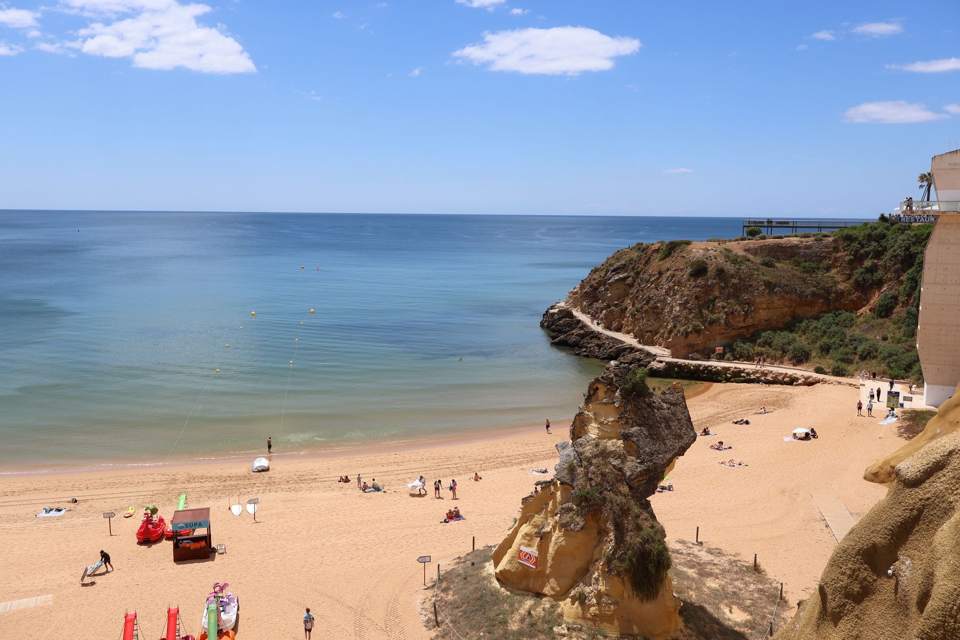 Zlaté vápencové útesy a tyrkysové moře na pláži Praia da Marinha v Algarve