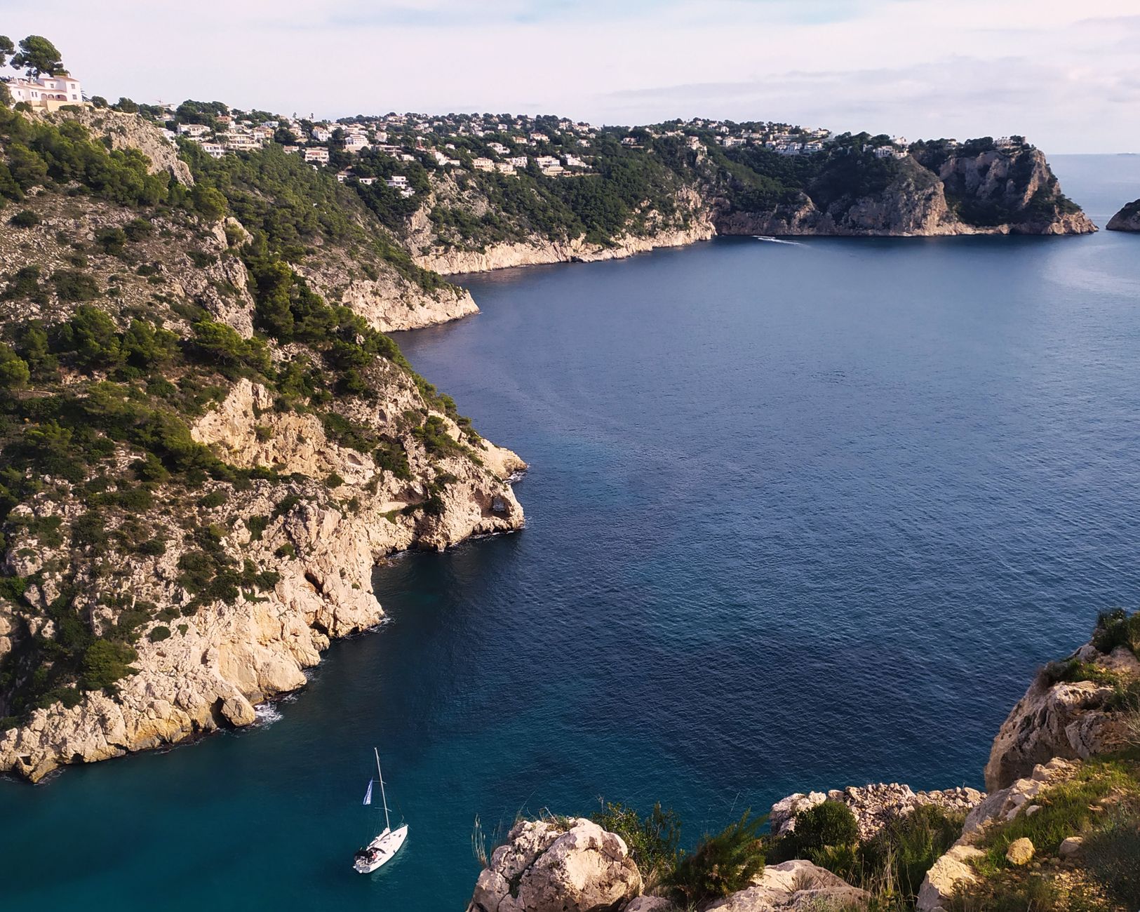 Pobřeží Costa Brava ve Španělsku s tyrkysovým mořem, skalnatými zátokami a borovicemi nad pláží