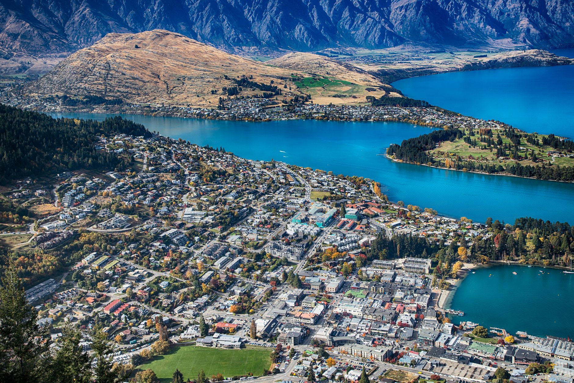 Kabinková lanovka Skyline stoupající nad Queenstown s výhledem na jezero a hory