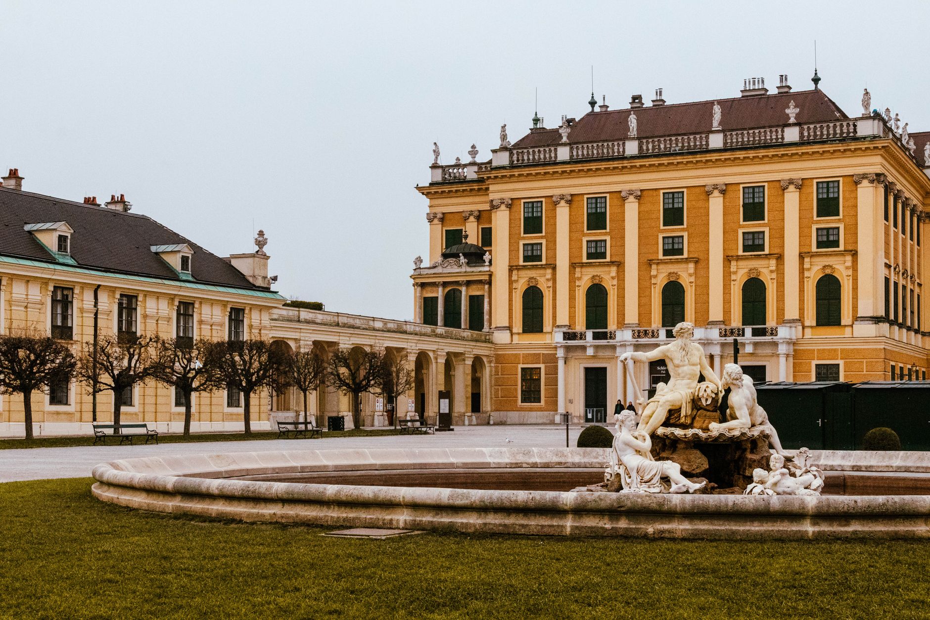 Zámek Schönbrunn ve Vídni se symetrickou barokní zahradou a kašnou v popředí