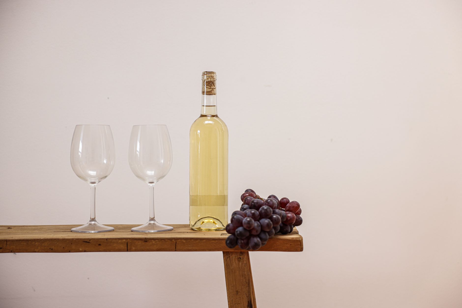 Sklenka bílého vína grüner veltliner na dřevěném stole rakouské vinařské hospůdky