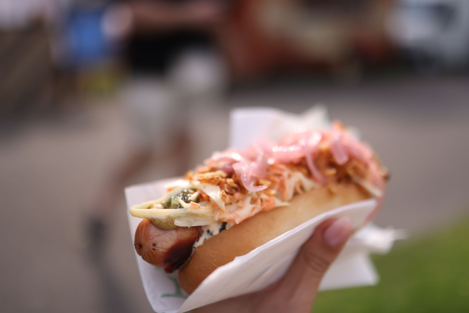 Islandský hot dog pylsur s dresinky a smaženou cibulkou v pečivu