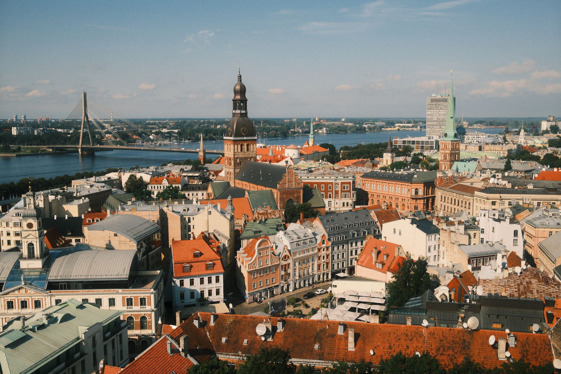 Panorama starého města Rigy s věží kostela svatého Petra a červenými střechami nad řekou Daugavou