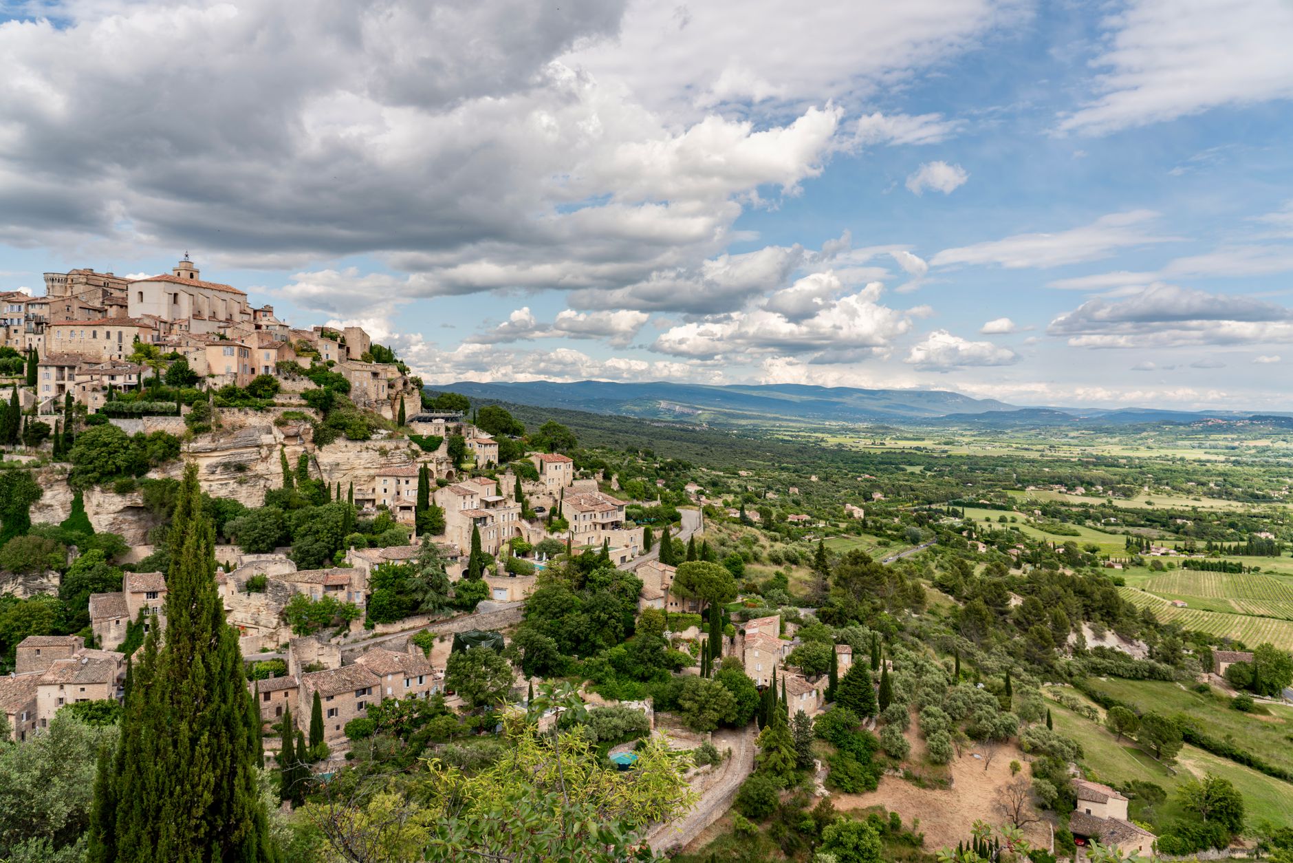 Sklenice růžového vína a provensálské olivy na stole s výhledem na vinice u Saint-Tropez