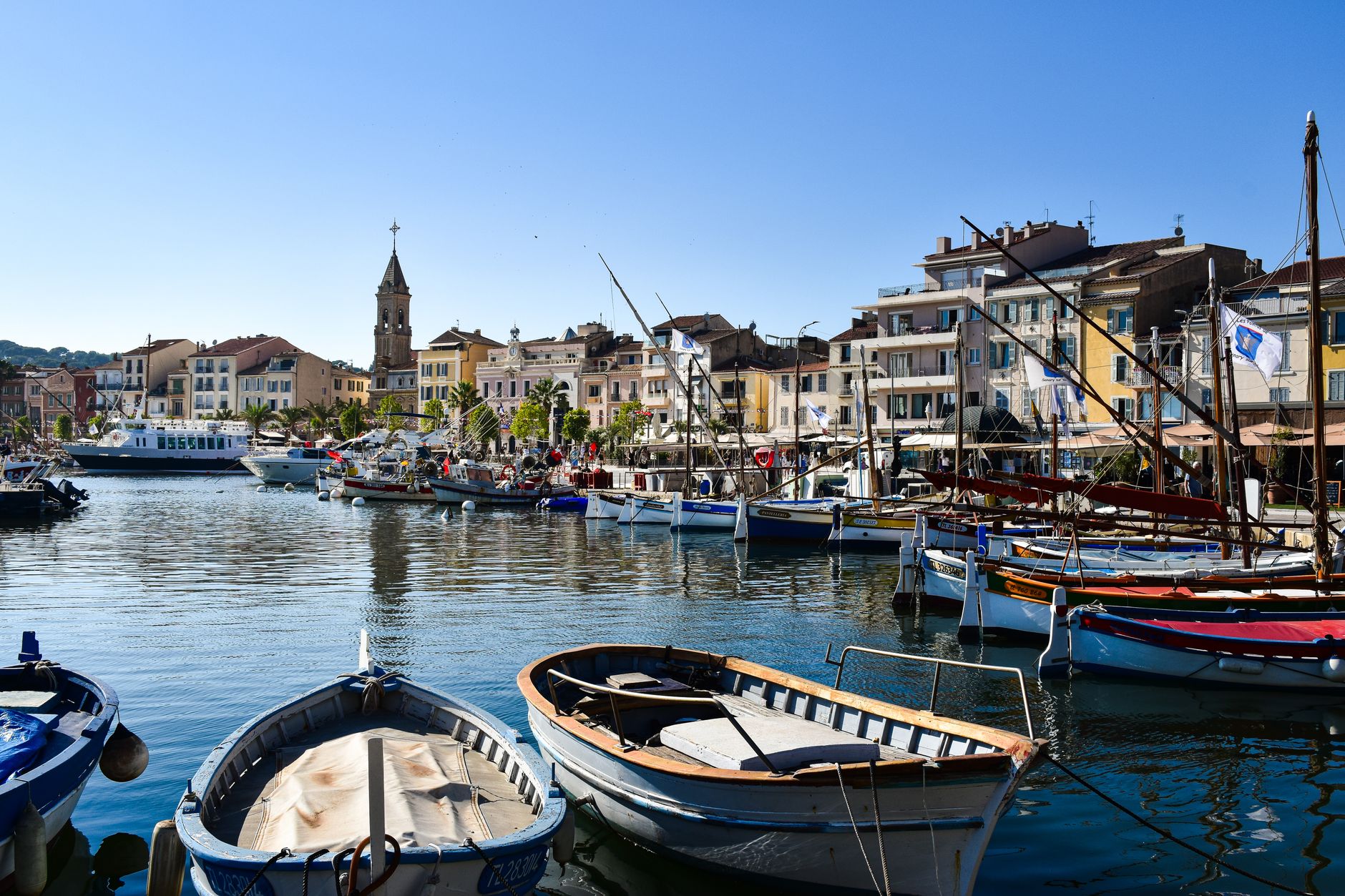 Pohled na přístav v Saint-Tropez s pastelovými domy a plachetnicemi na Francouzské riviéře