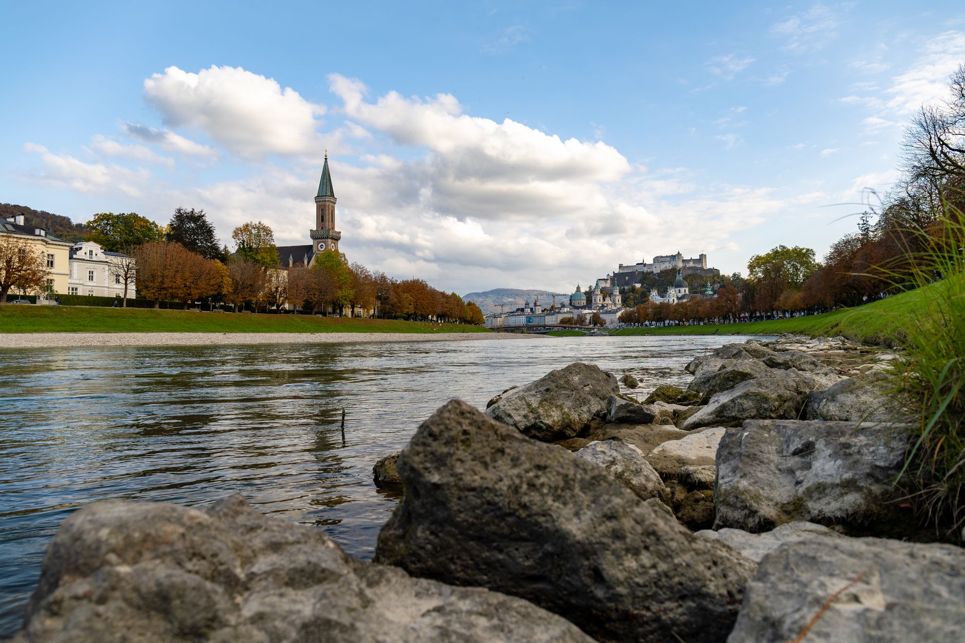 Řeka Salzach protékající Salzburgem s pohledem na staré město a věže kostelů
