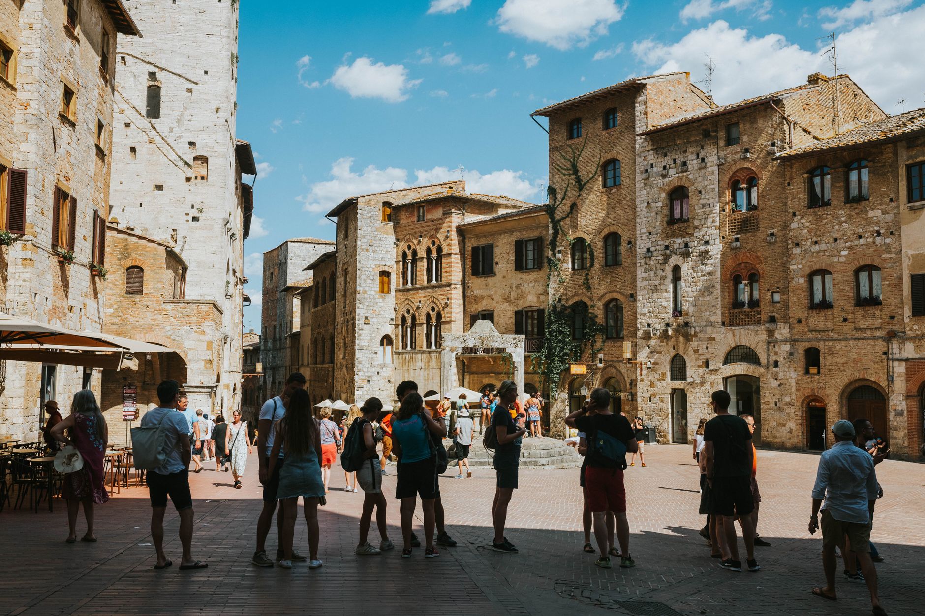 Historická studna na náměstí Piazza della Cisterna v San Gimignanu obklopená středověkými domy