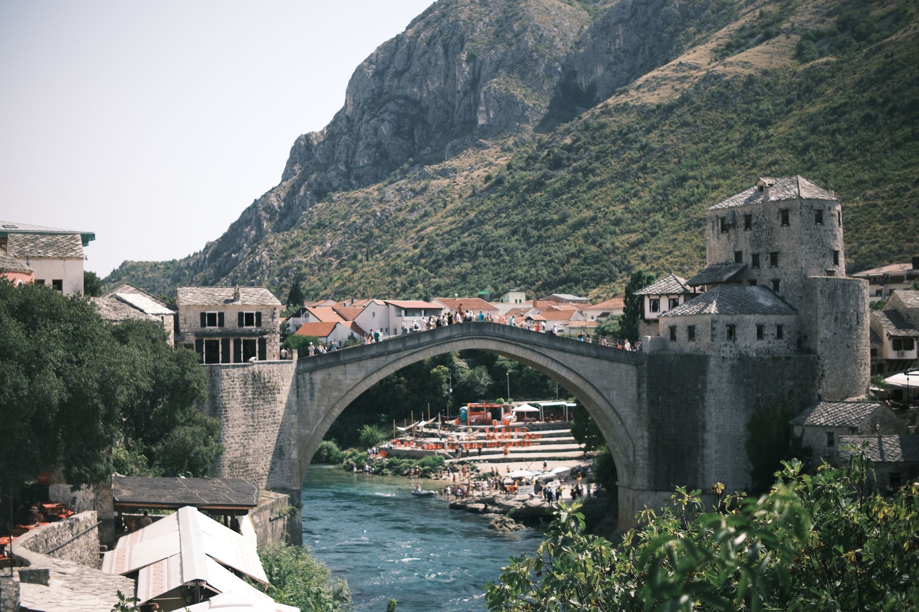Kamenný most Stari Most ve městě Mostar nad zelenou řekou Neretvou
