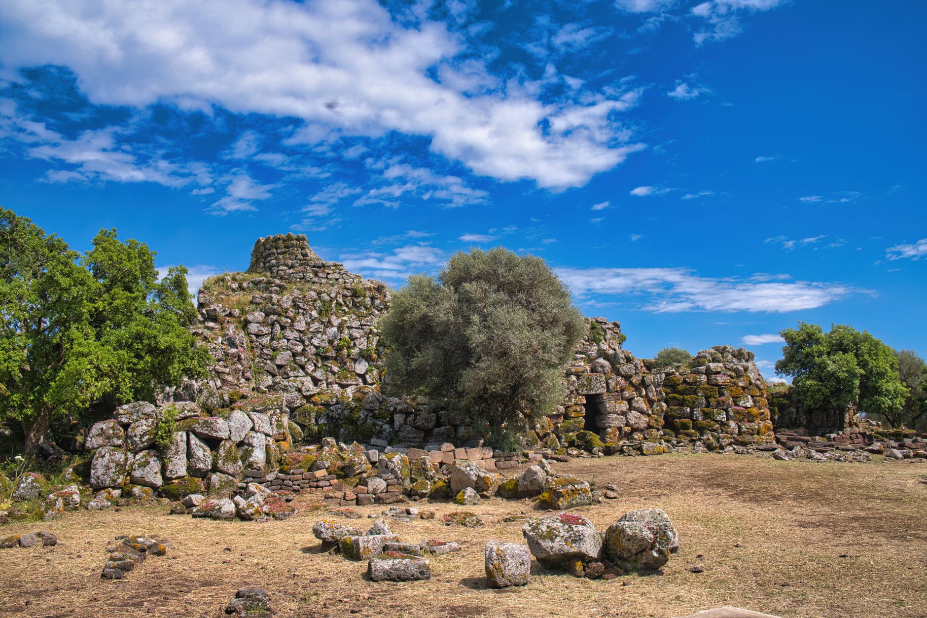 Prehistorická kamenná věž nuraghe na zelené pláni na Sardinii