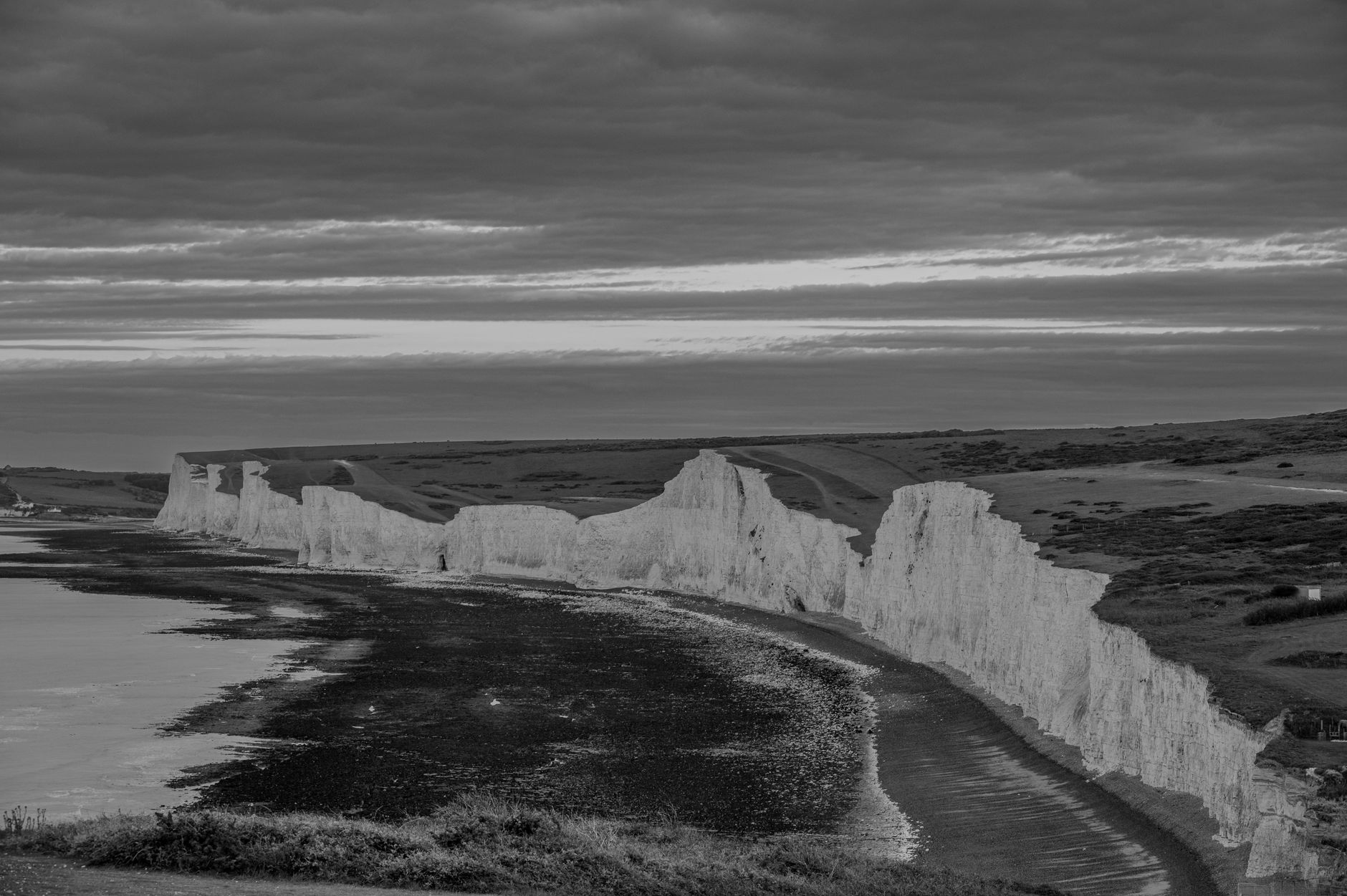 Bílé křídové útesy Seven Sisters nad zeleným údolím a kanálem La Manche na pobřeží jižní Anglie