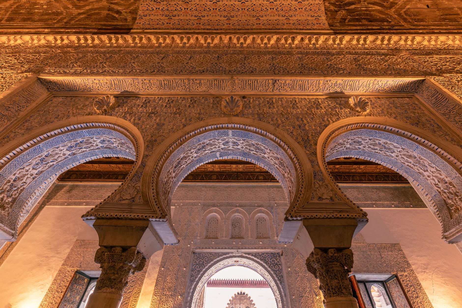 Maurská architektura paláce Real Alcázar v Seville s vyřezávanými oblouky a azulejos