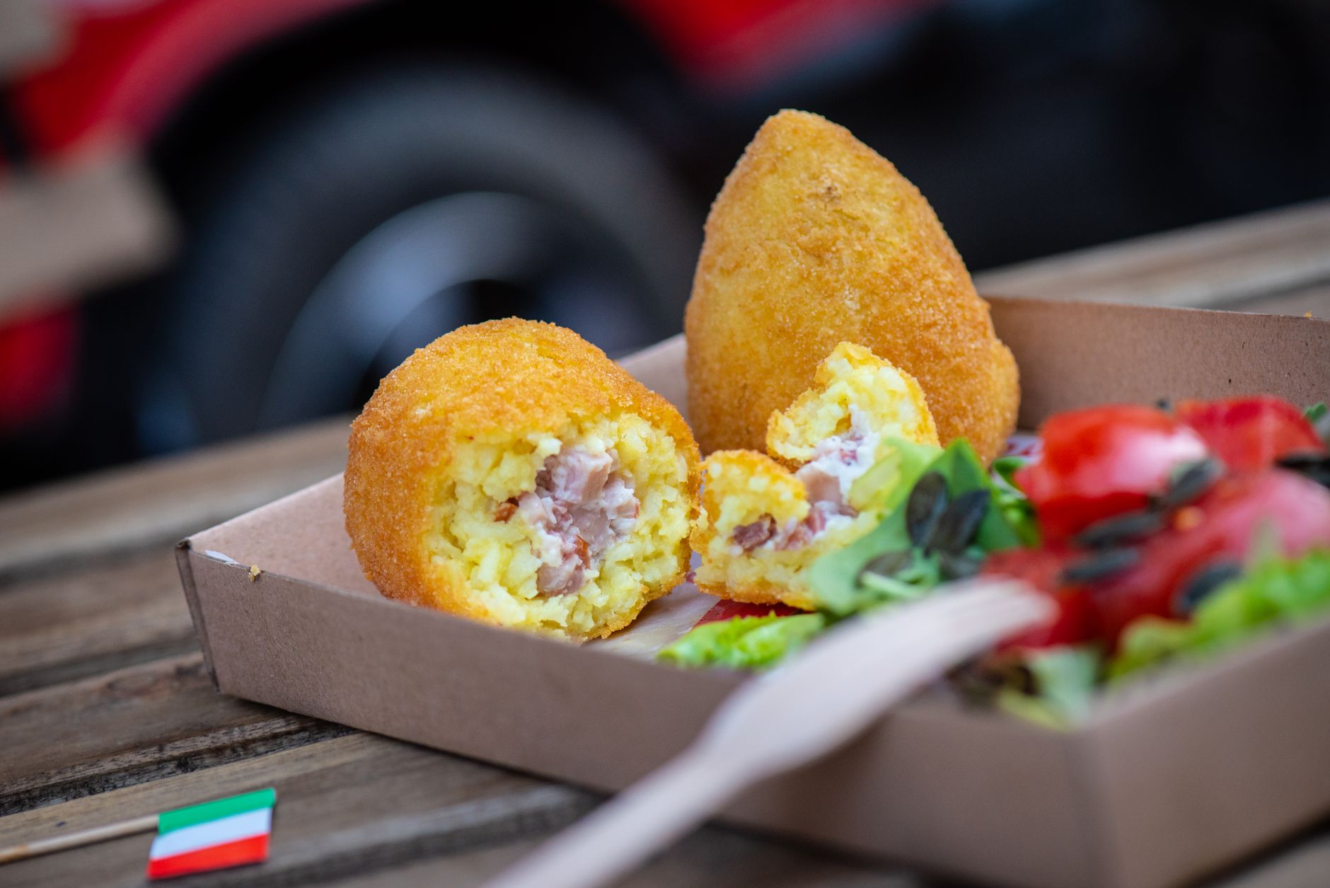 Talíř sicilských arancini, smažených rýžových koulí, na stole