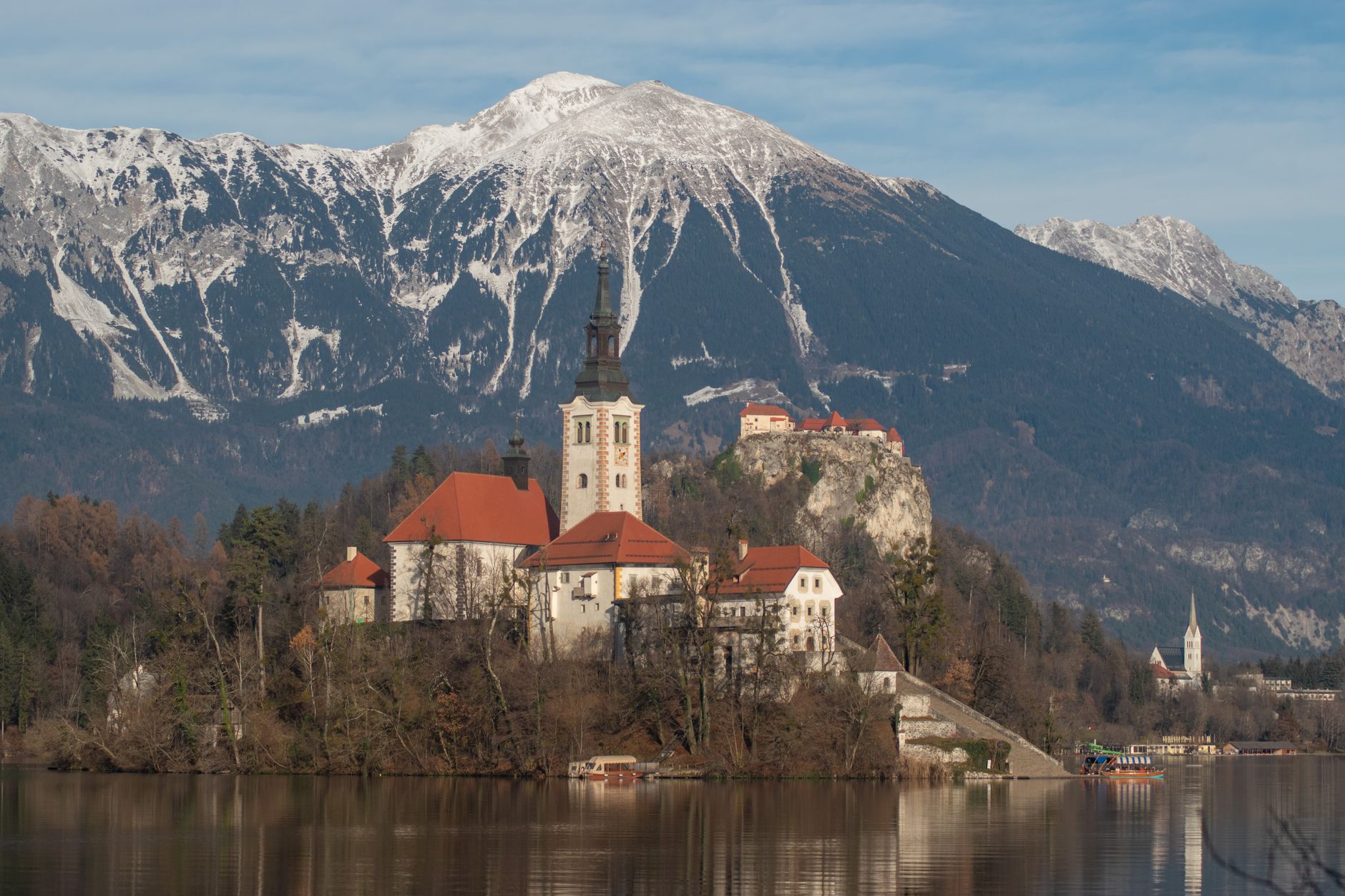 Jezero Bled s ostrůvkem, kostelíkem a hradem nad vodou ve slovinských Alpách