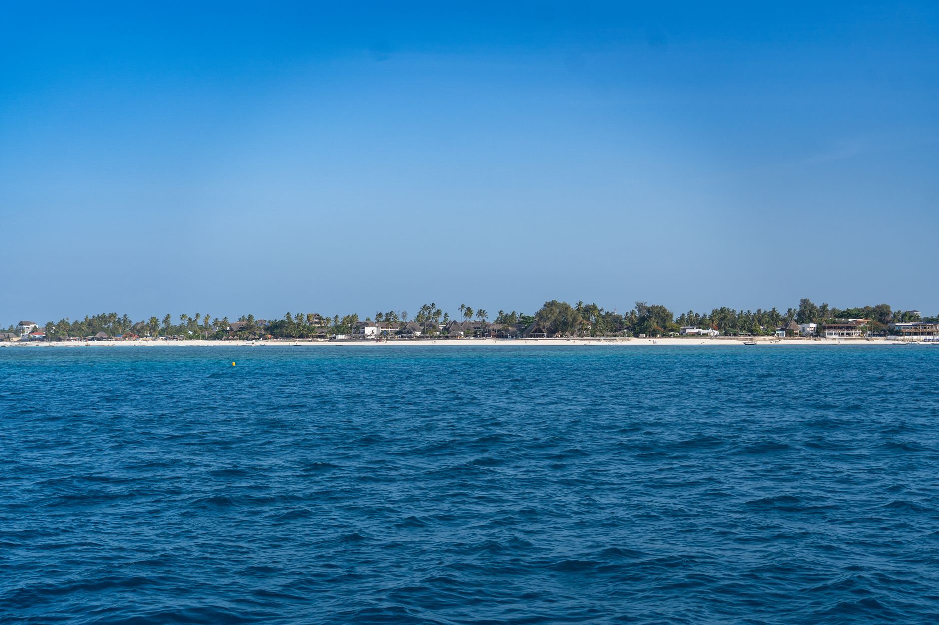 Bílá pláž s palmami a tyrkysovou lagunou na ostrově Zanzibar v Tanzanii