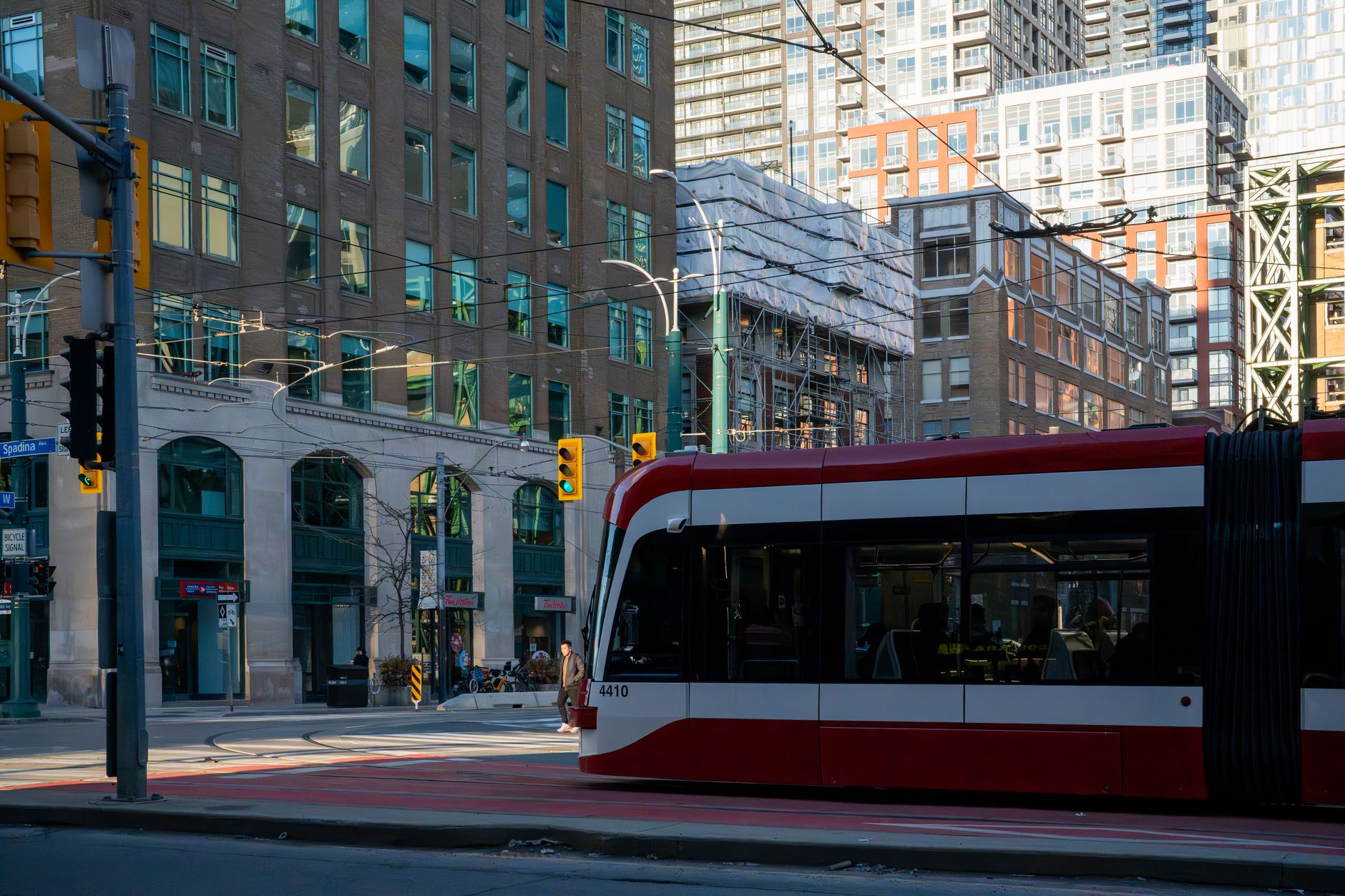 Červená tramvaj TTC projíždějící ulicí centra Toronta mezi mrakodrapy