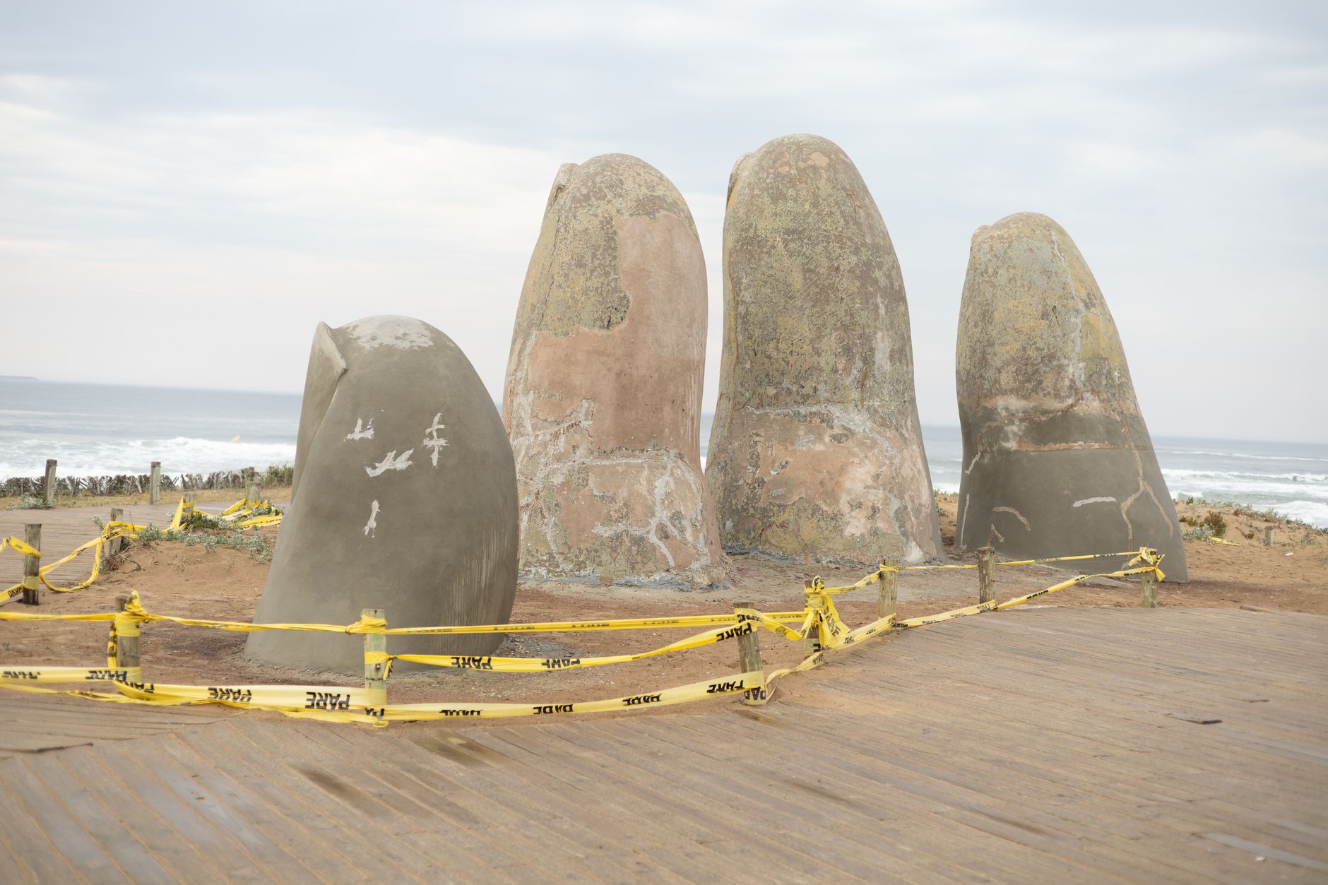 Betonová socha ruky La Mano vyčnívající z písku na pláži v Punta del Este v Uruguayi