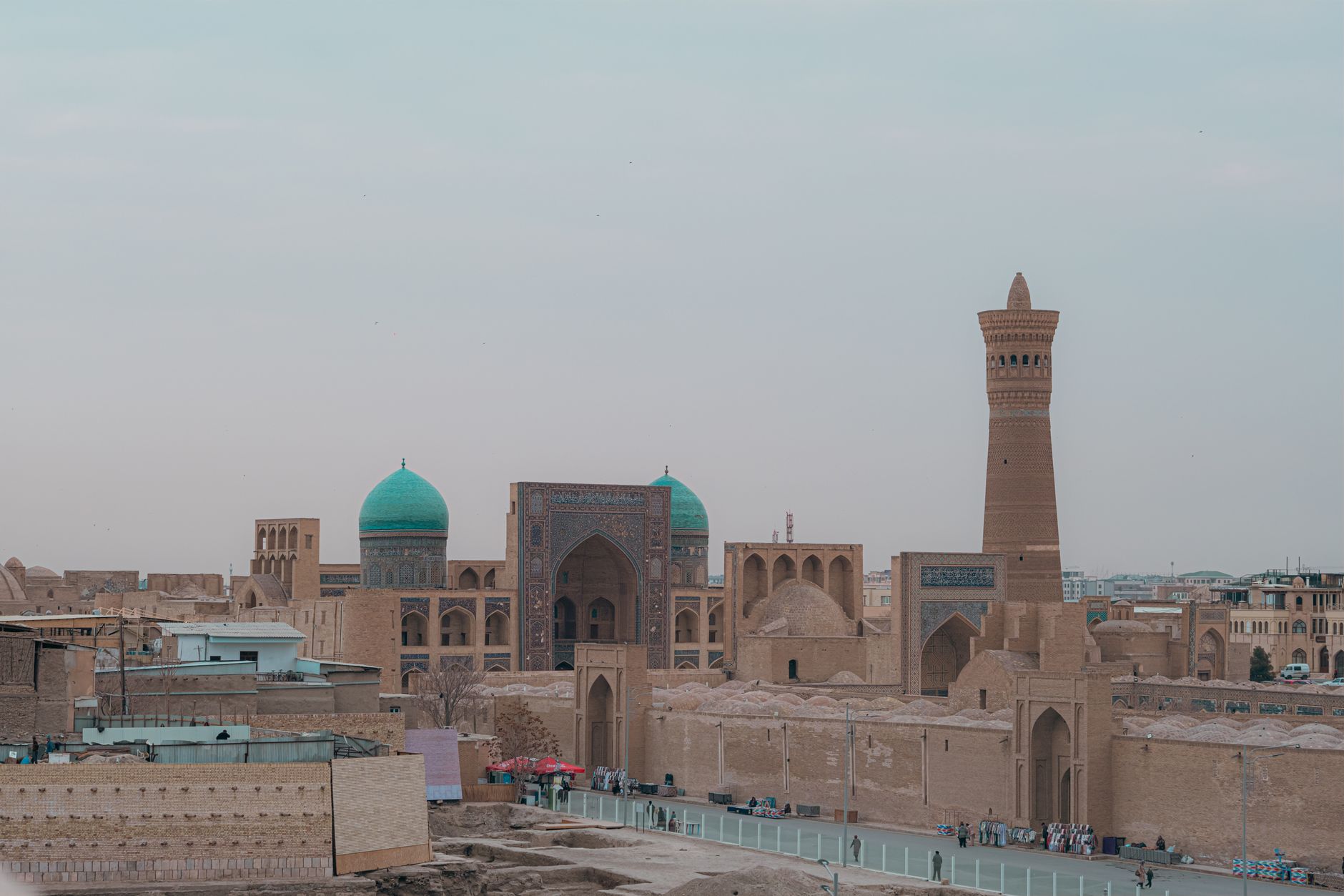 Vysoký minaret Kaljan a modrá kupole mešity ve starém městě Buchara