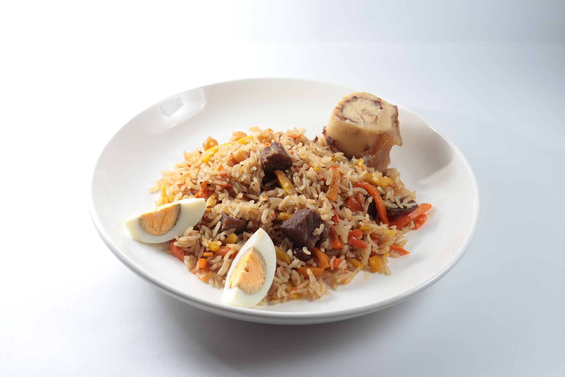Tradiční uzbecký plov s rýží, masem a mrkví podávaný na velkém talíři
