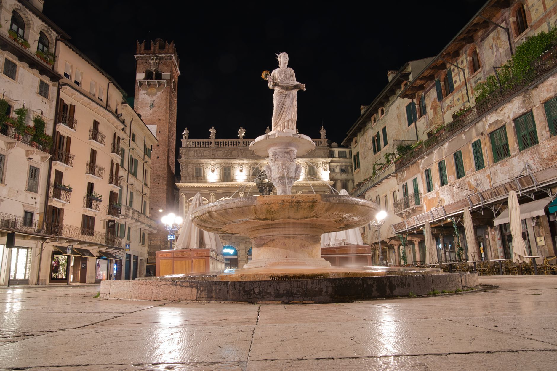 Středověké náměstí Piazza delle Erbe ve Veroně s freskami na fasádách a fontánou