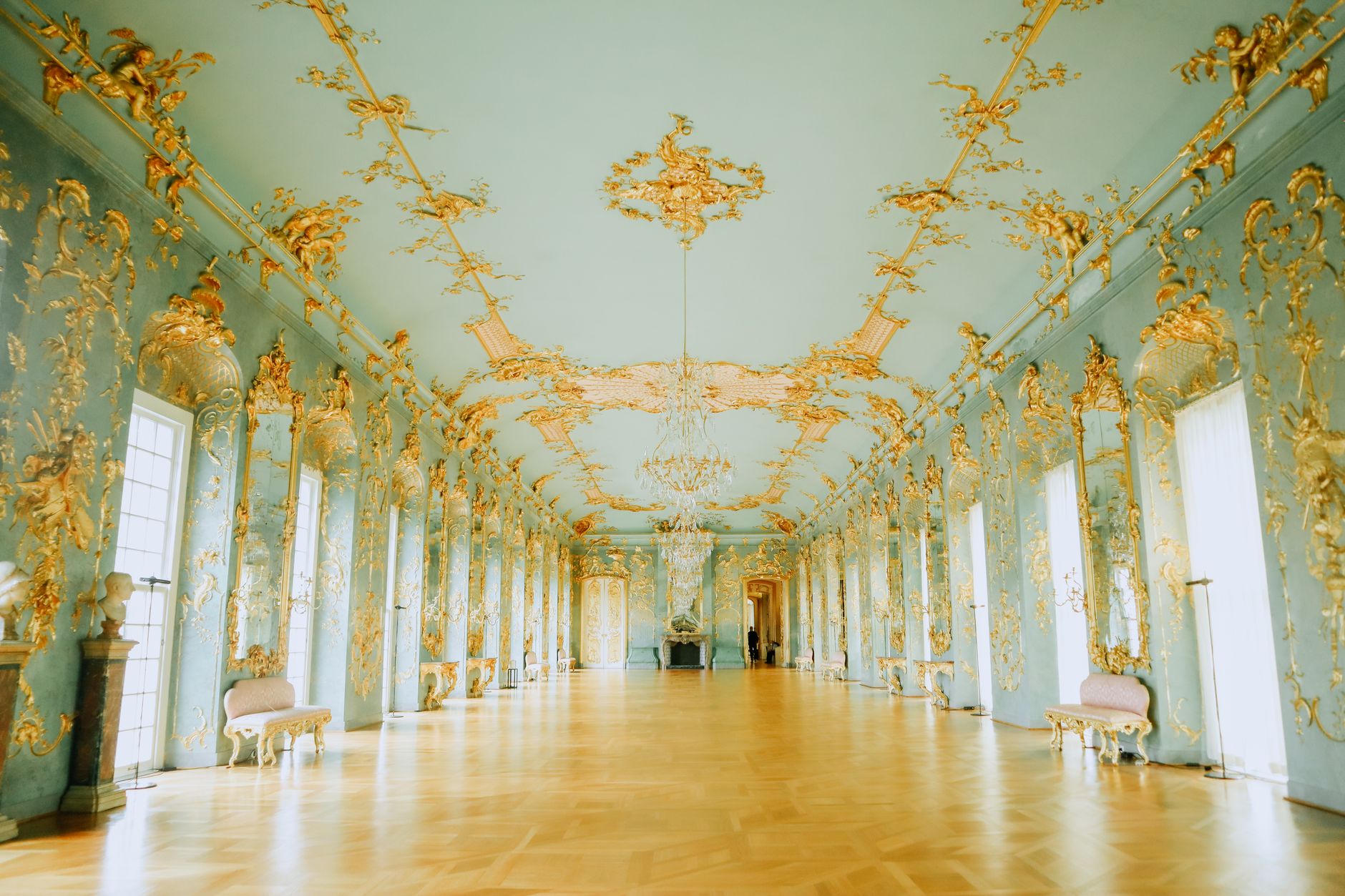 Zlacená brána zámku Versailles s královským znakem ve slunci