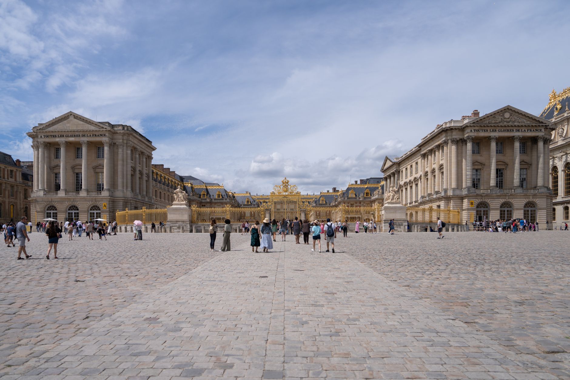 Zámek Versailles s rozlehlou fasádou a francouzskou zahradou v popředí