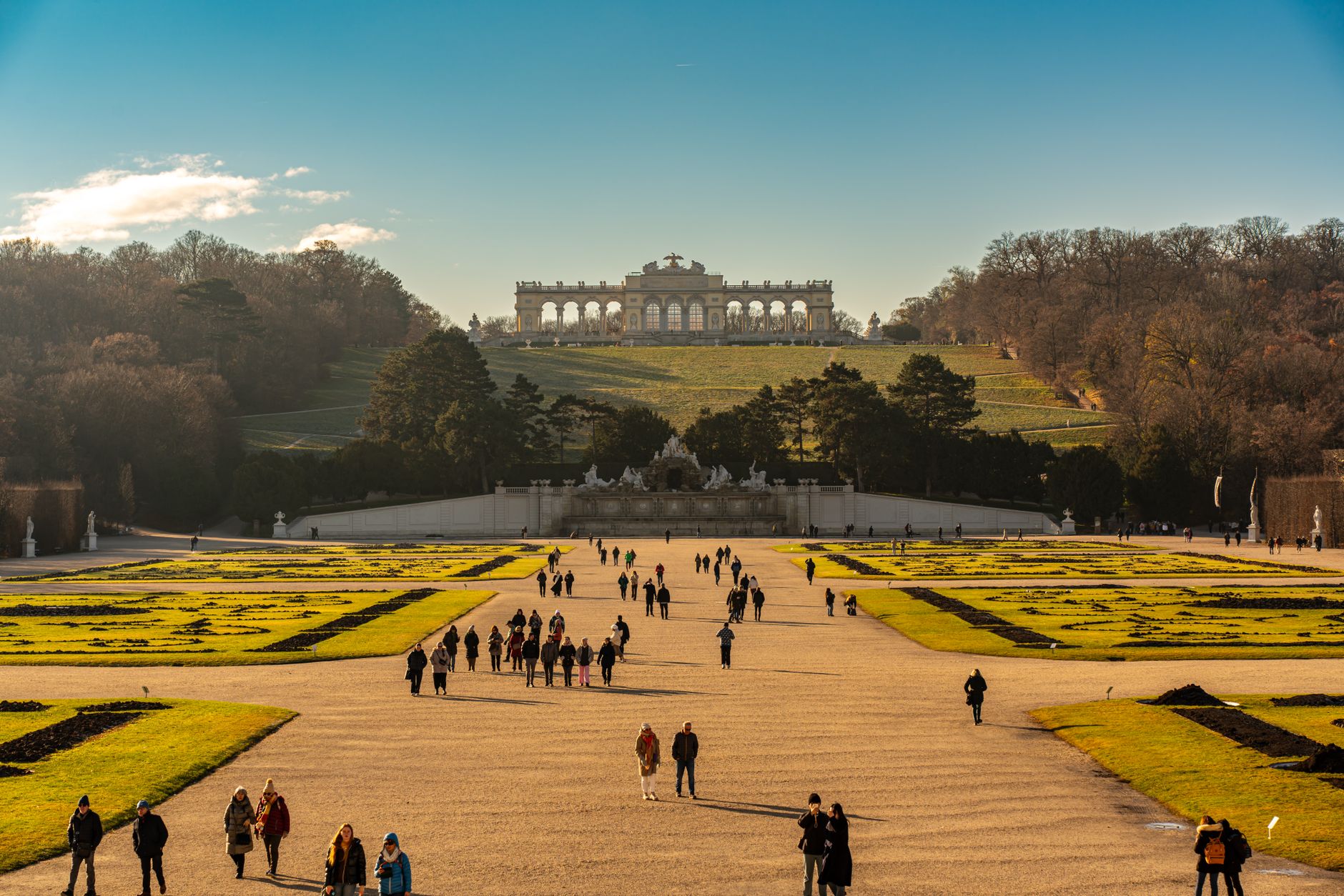 Žlutá fasáda a zahrady zámku Schönbrunn ve Vídni s gloriettou na kopci v pozadí