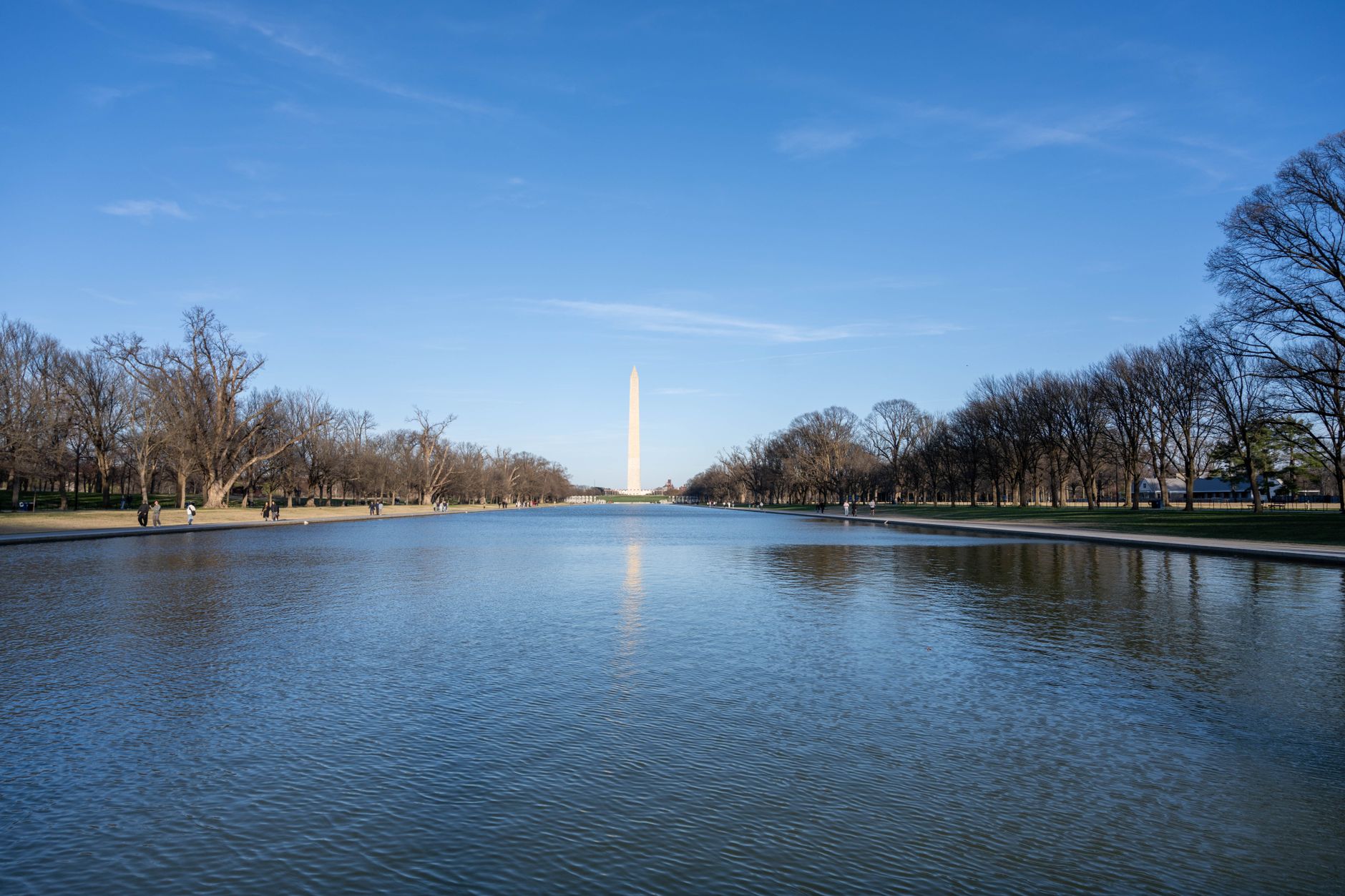 Washingtonův monument bílý obelisk odrážející se ve vodní hladině na National Mall